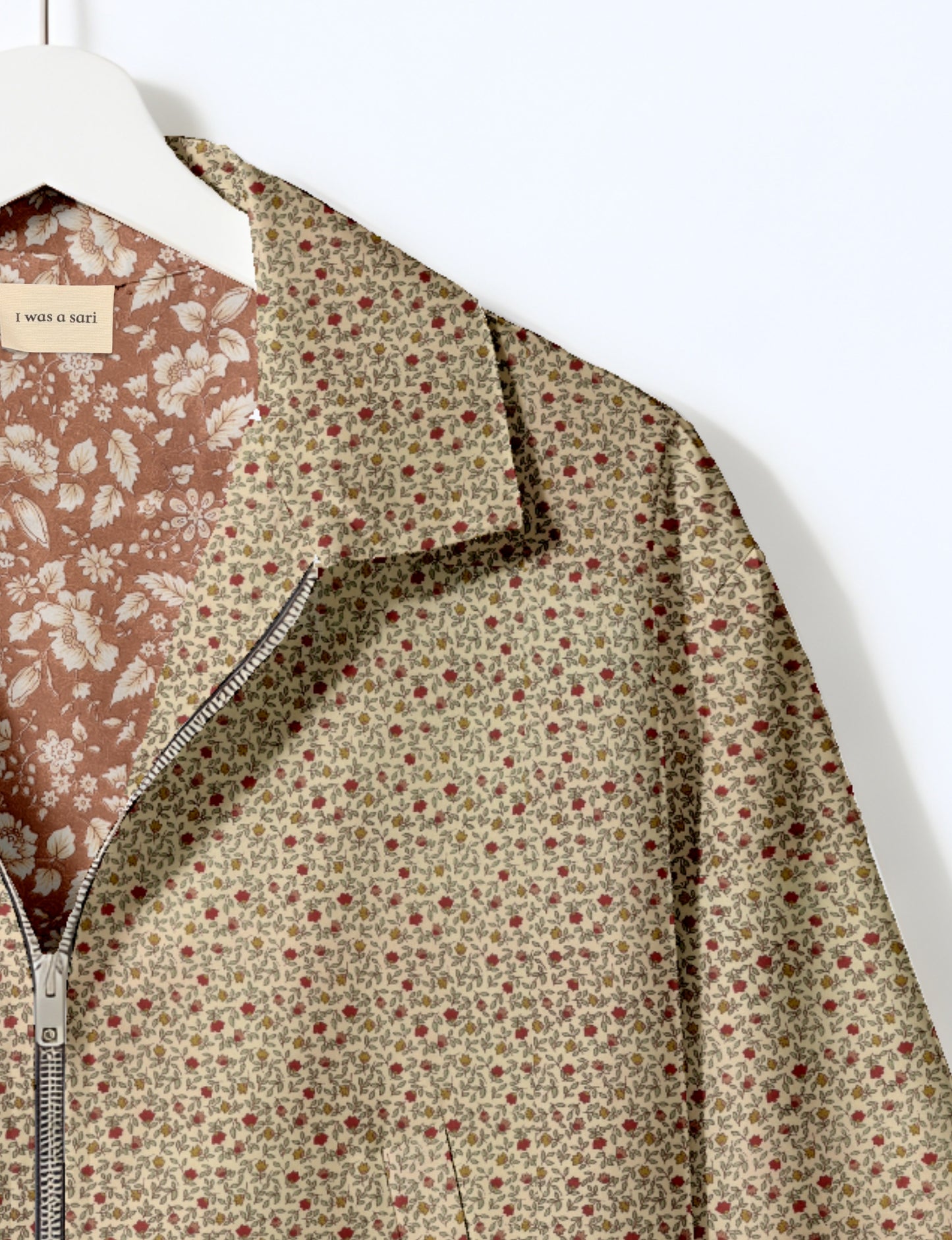 Women's cropped bomber jacket with twin metallic front zippers, welt pockets, elasticated hem and cuffs, and contrast sari print lining.