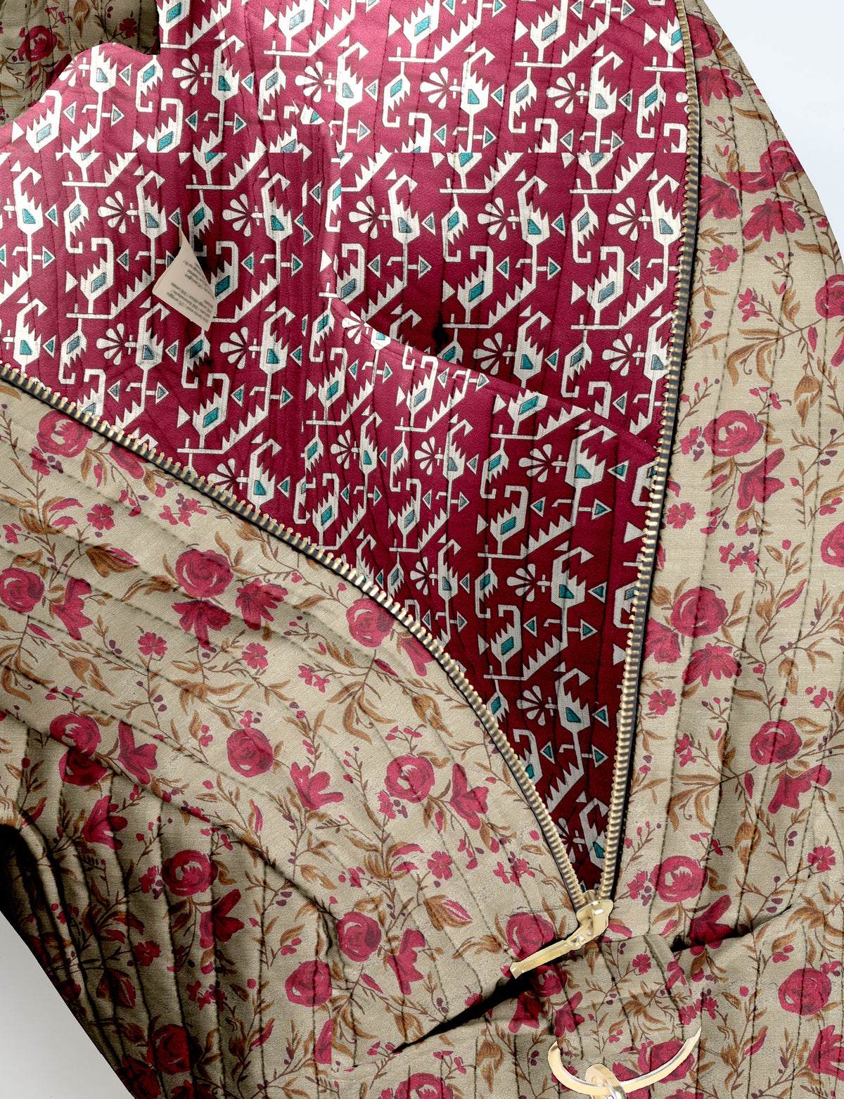 Brown quilted duffle bag with paisley pattern, front zip pocket, dual handles, and label reading "I was a sari"