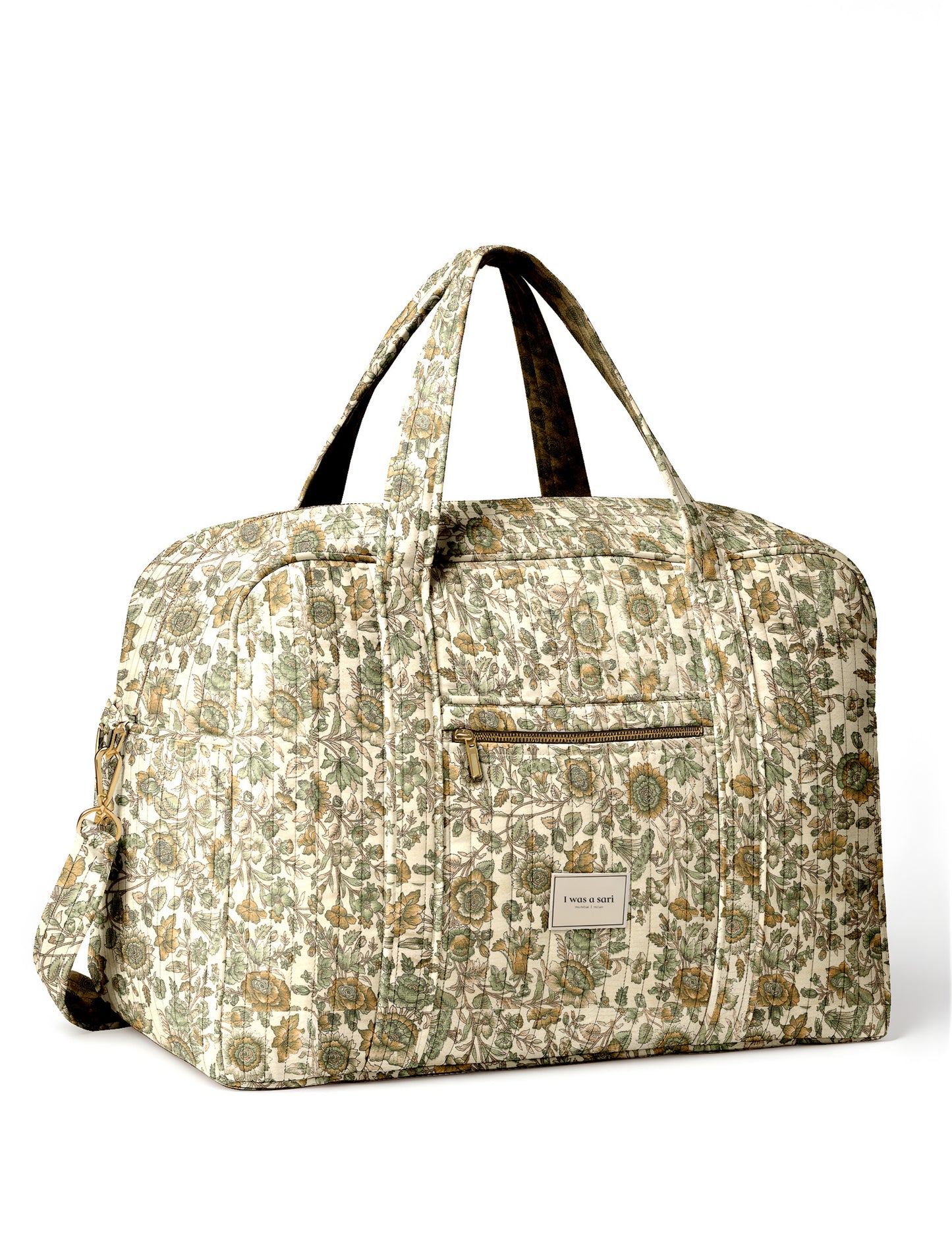 Brown quilted duffle bag with paisley pattern, front zip pocket, dual handles, and label reading "I was a sari"