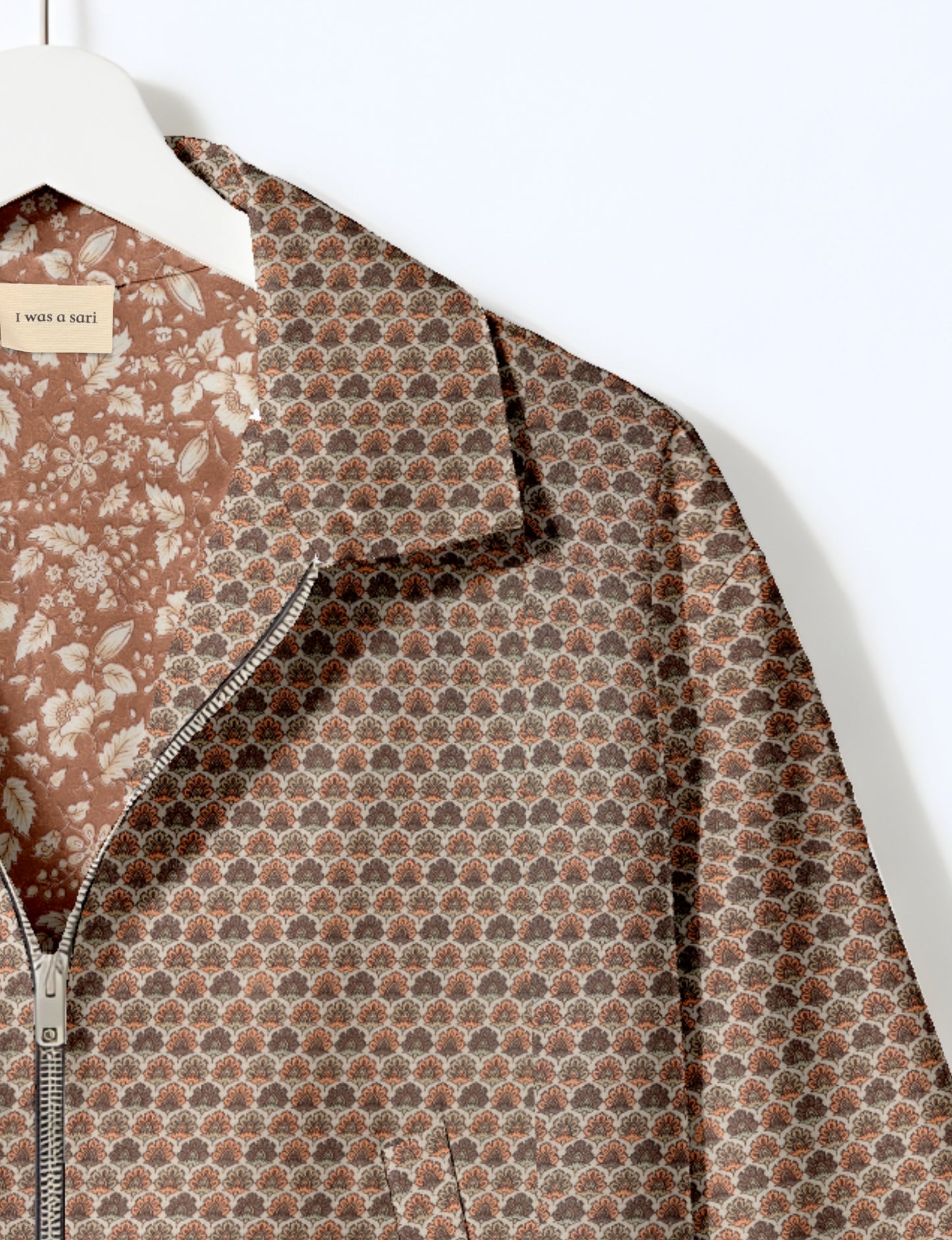 Women's cropped bomber jacket with twin metallic front zippers, welt pockets, elasticated hem and cuffs, and contrast sari print lining.