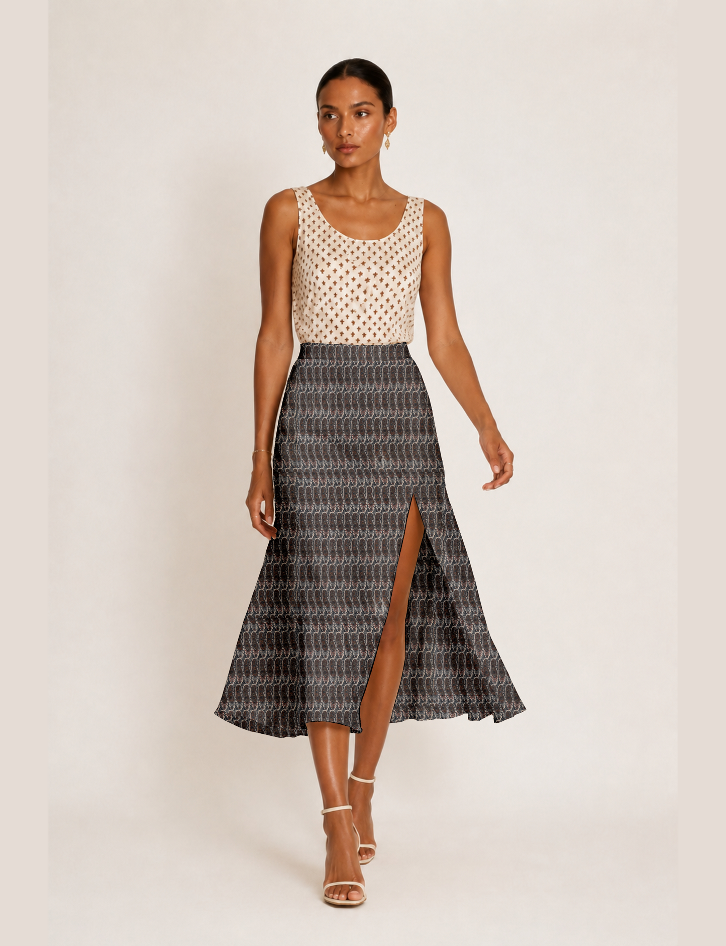 Woman wearing a yellow and black micro patterned A-line skirt with front slit, paired with beige sleeveless top and black