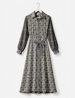Long shirt dress with beige and dark blue floral and stripe patterns, button front, long sleeves, and waist tie, hanging on