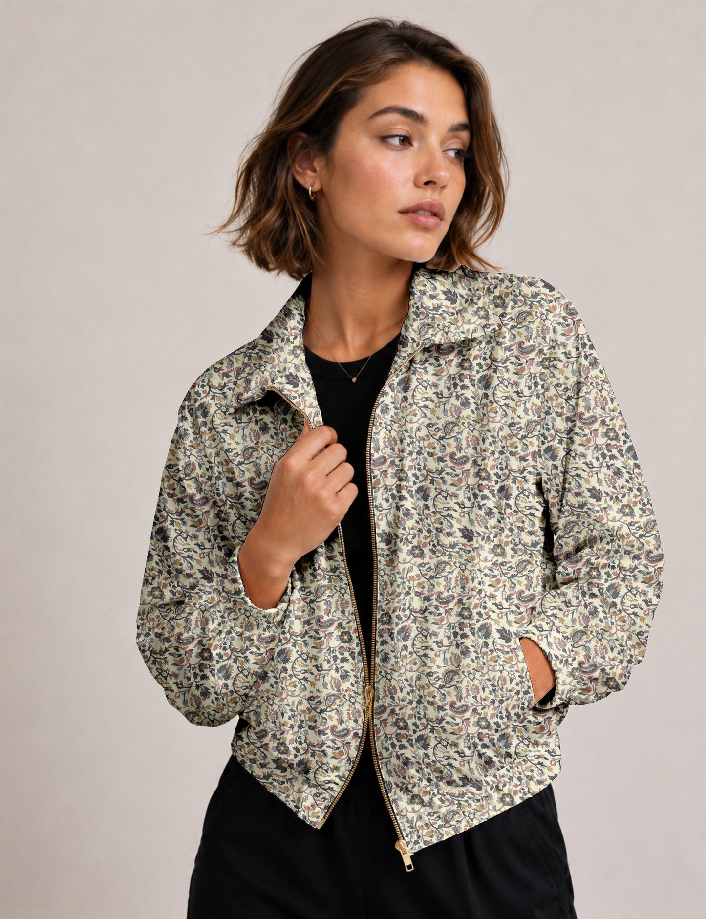 Woman wearing a yellow floral bomber jacket with front zipper, elastic cuffs, and side pockets, shown from front view