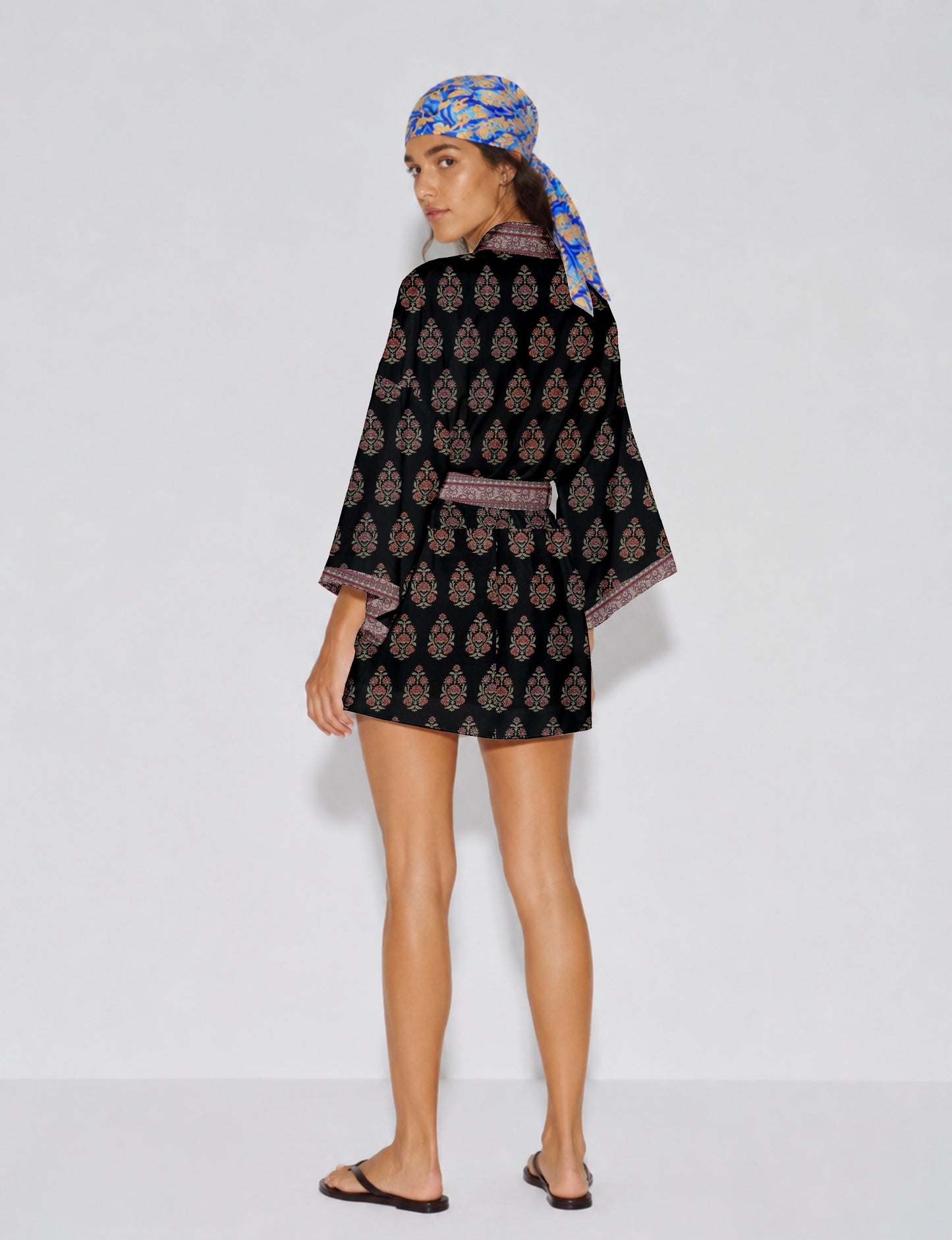 Short kimono robe with wrap front, V-neckline, wide sleeves, waist tie, and concealed skort detail.