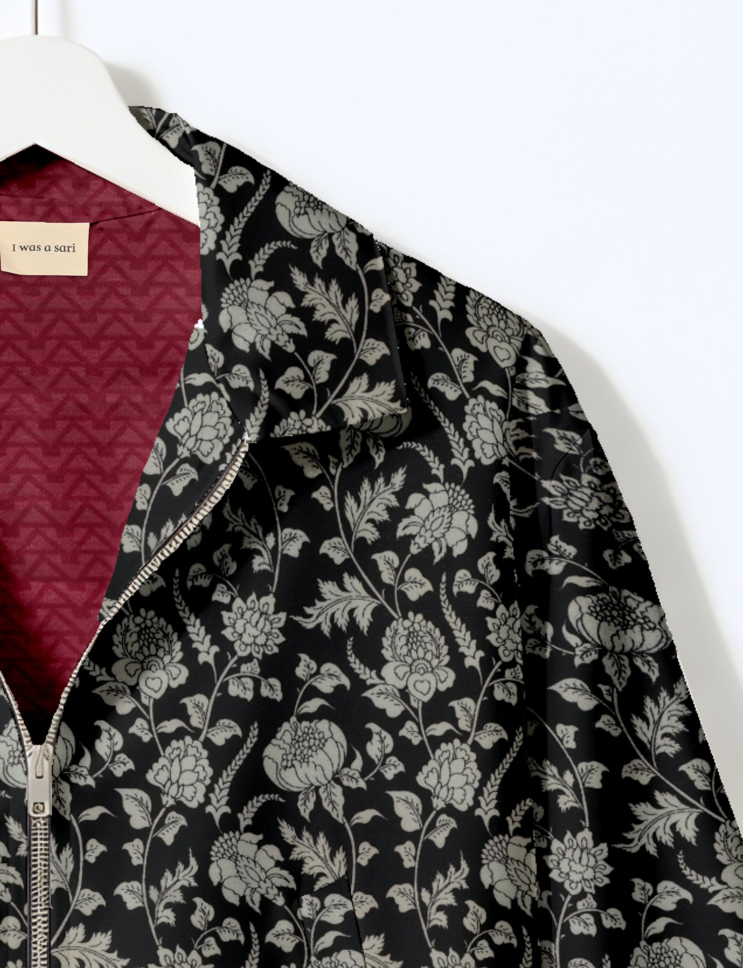 Women's cropped bomber jacket with twin metallic front zippers, welt pockets, elasticated hem and cuffs, and contrast sari print lining.