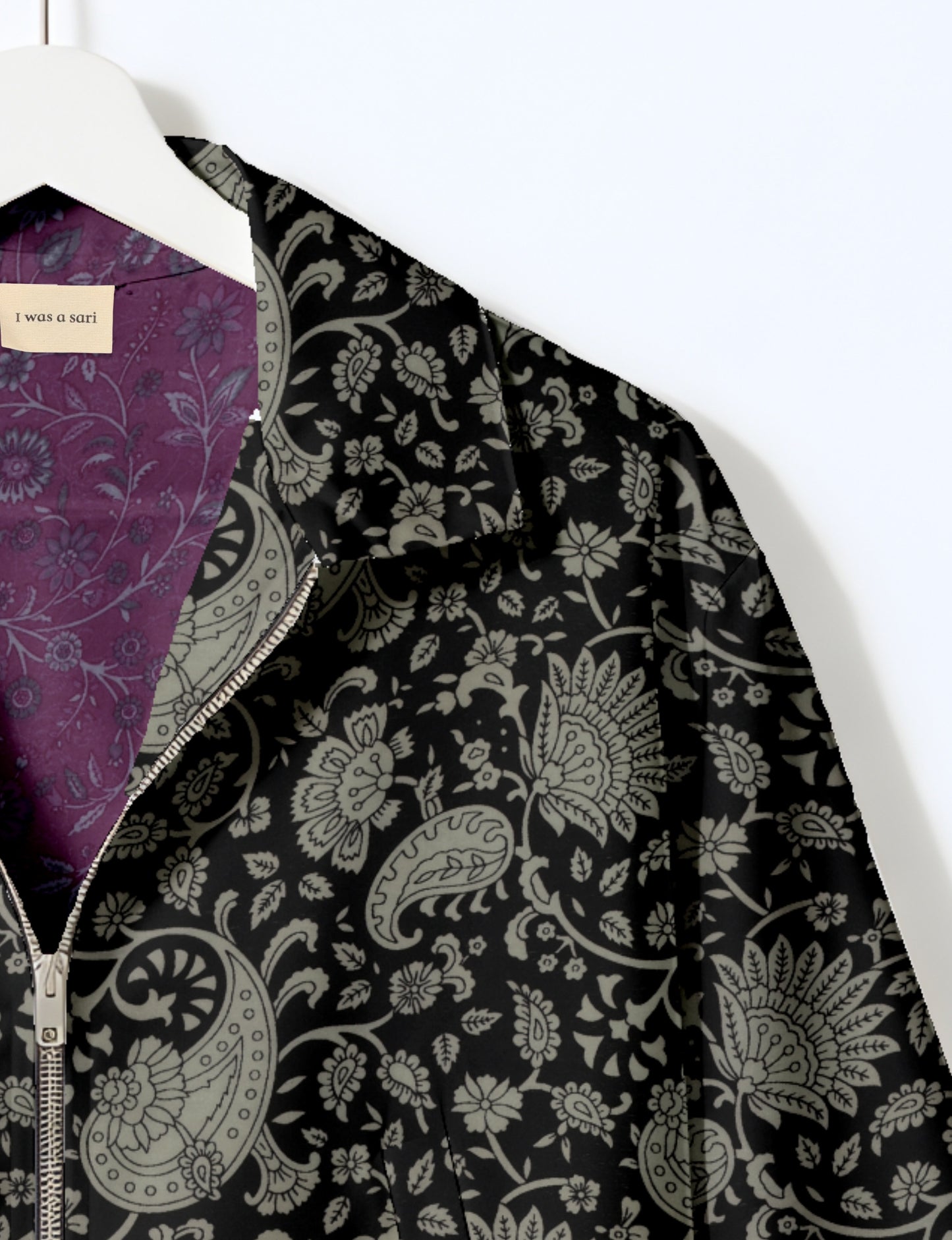 Women's cropped bomber jacket with twin metallic front zippers, welt pockets, elasticated hem and cuffs, and contrast sari print lining.