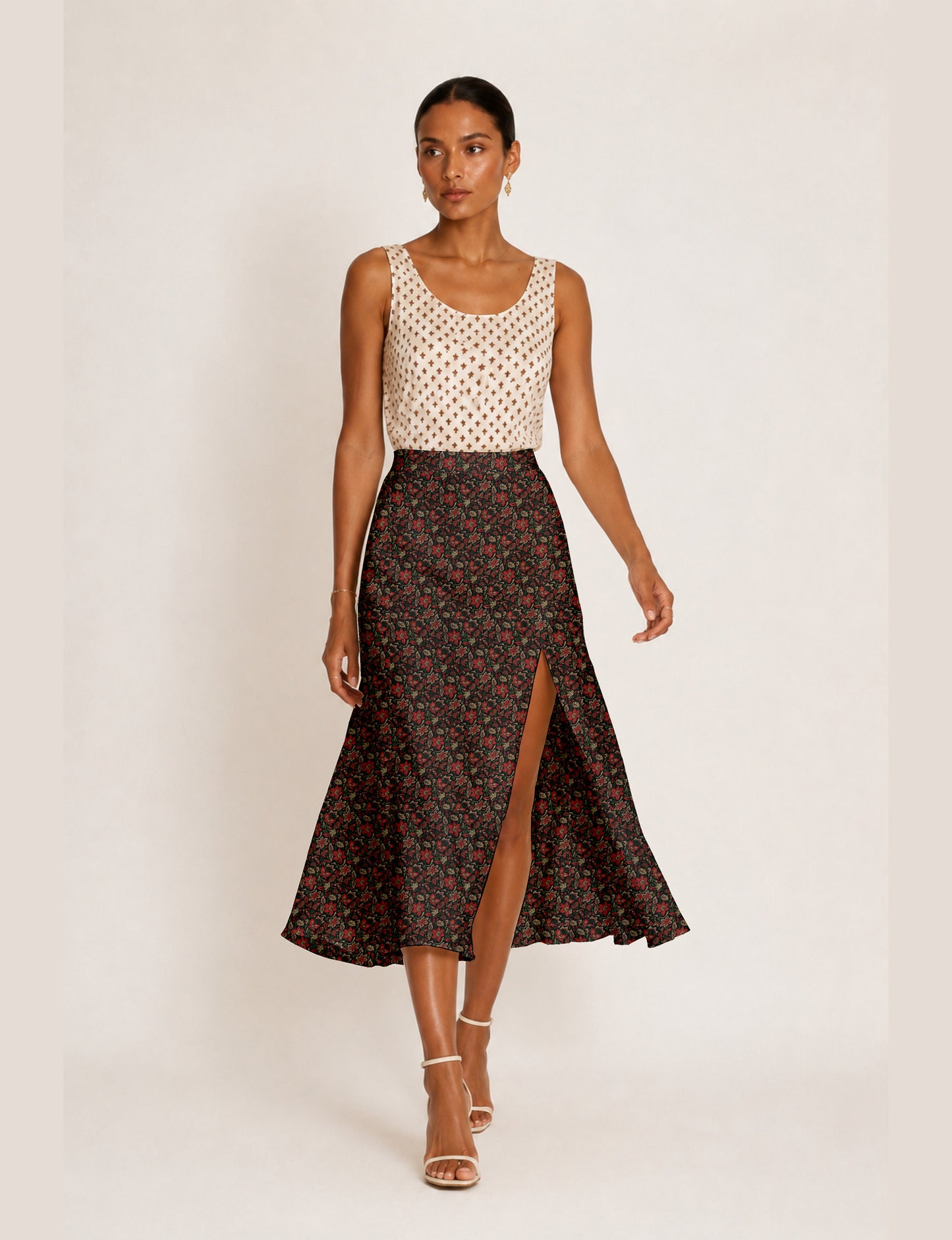 Woman wearing a yellow and black micro patterned A-line skirt with front slit, paired with beige sleeveless top and black