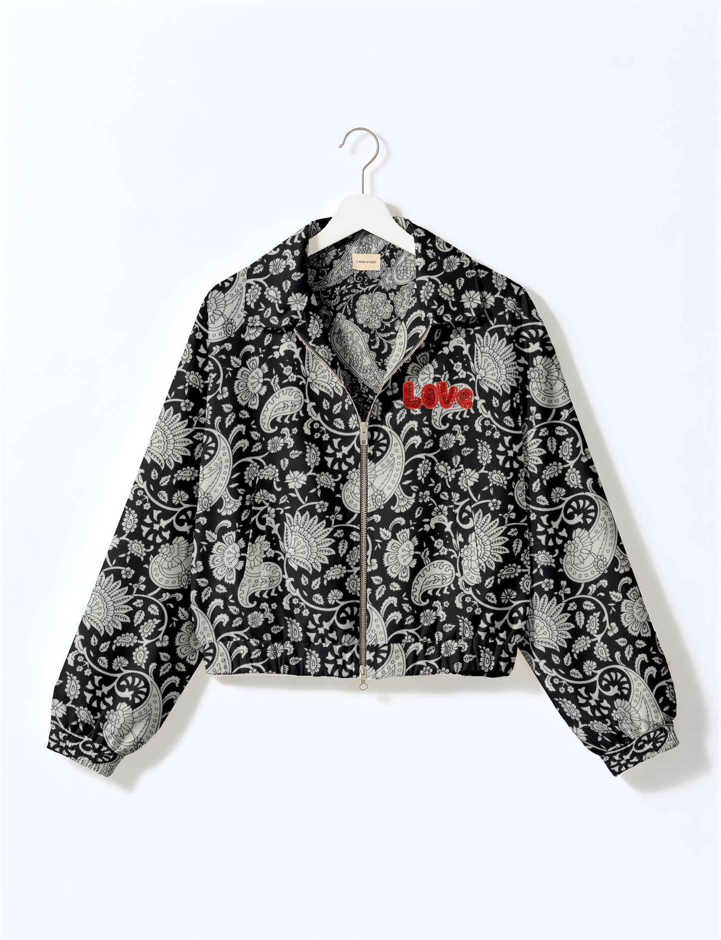 Black bomber jacket with white paisley floral pattern, front zipper, elastic cuffs, and red "Love" embroidery on chest