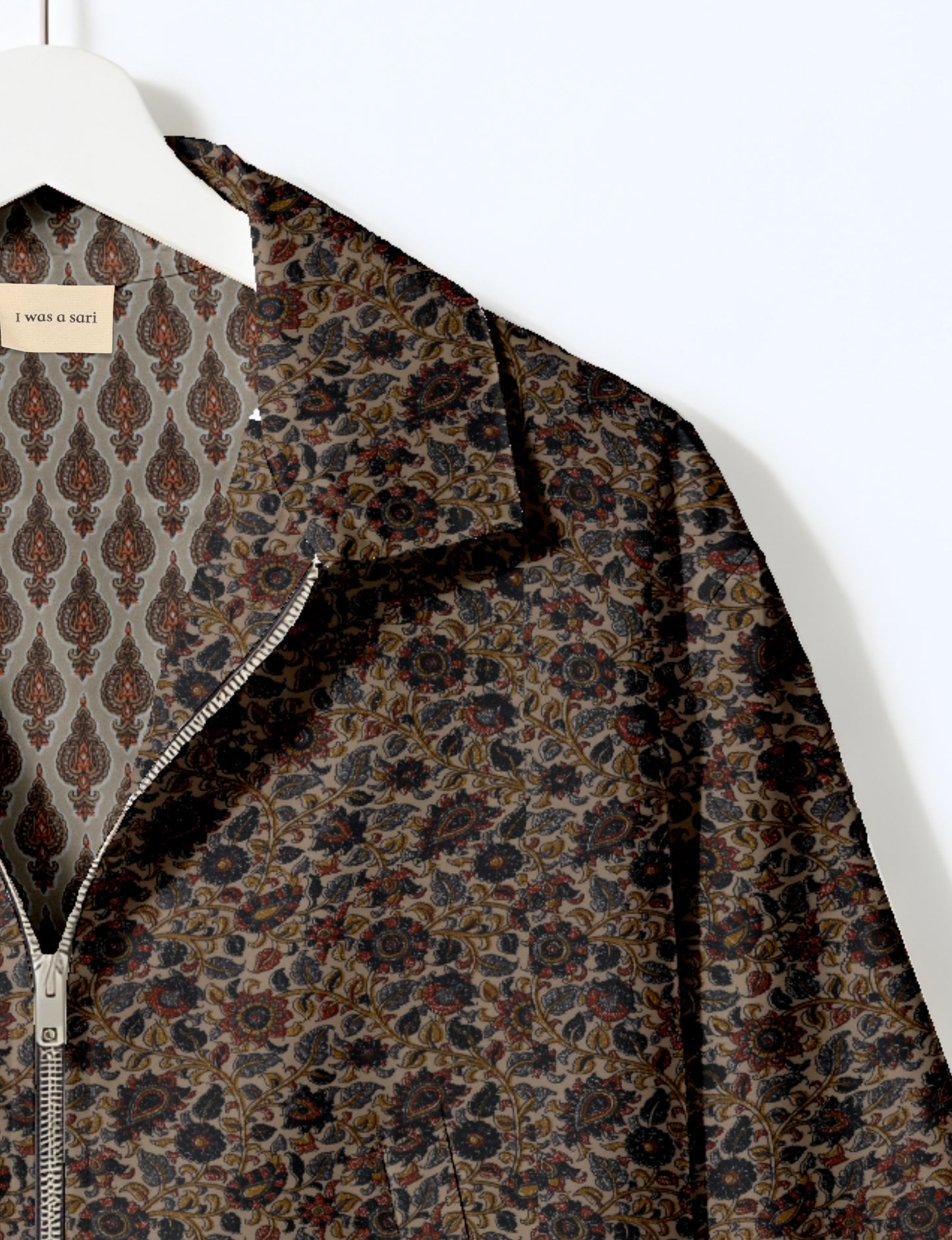 Women's cropped bomber jacket with twin metallic front zippers, welt pockets, elasticated hem and cuffs, and contrast sari print lining.