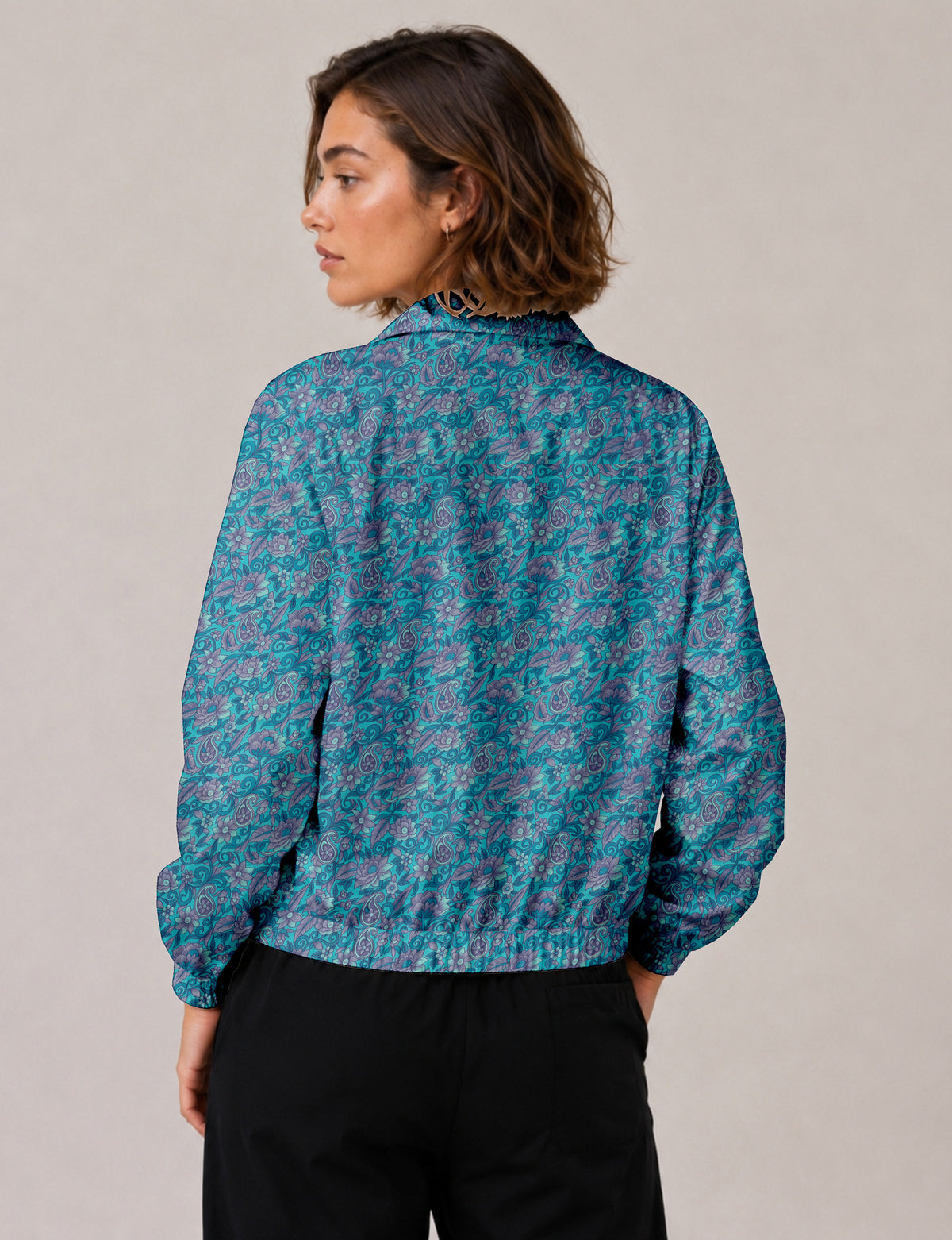 Woman wearing a yellow floral bomber jacket with front zipper, elastic cuffs, and side pockets, shown from front view