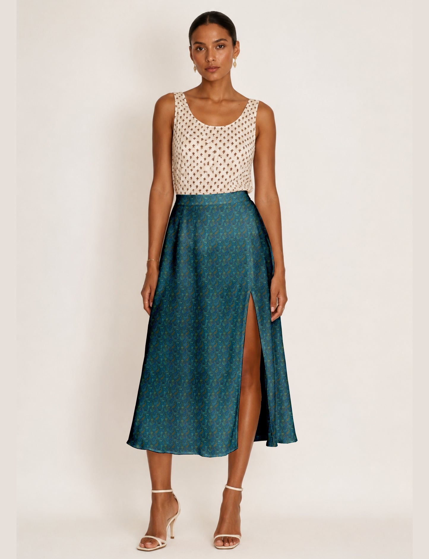 Woman wearing a yellow and navy blue A-line skirt with a slit and a sleeveless beige top with brown micro print