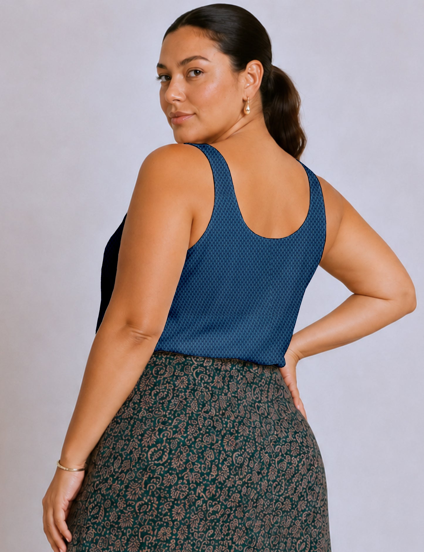 Women's sleeveless blouse with a relaxed straight fit, wide scoop neckline, deep scoop back, and hip-length silhouette.