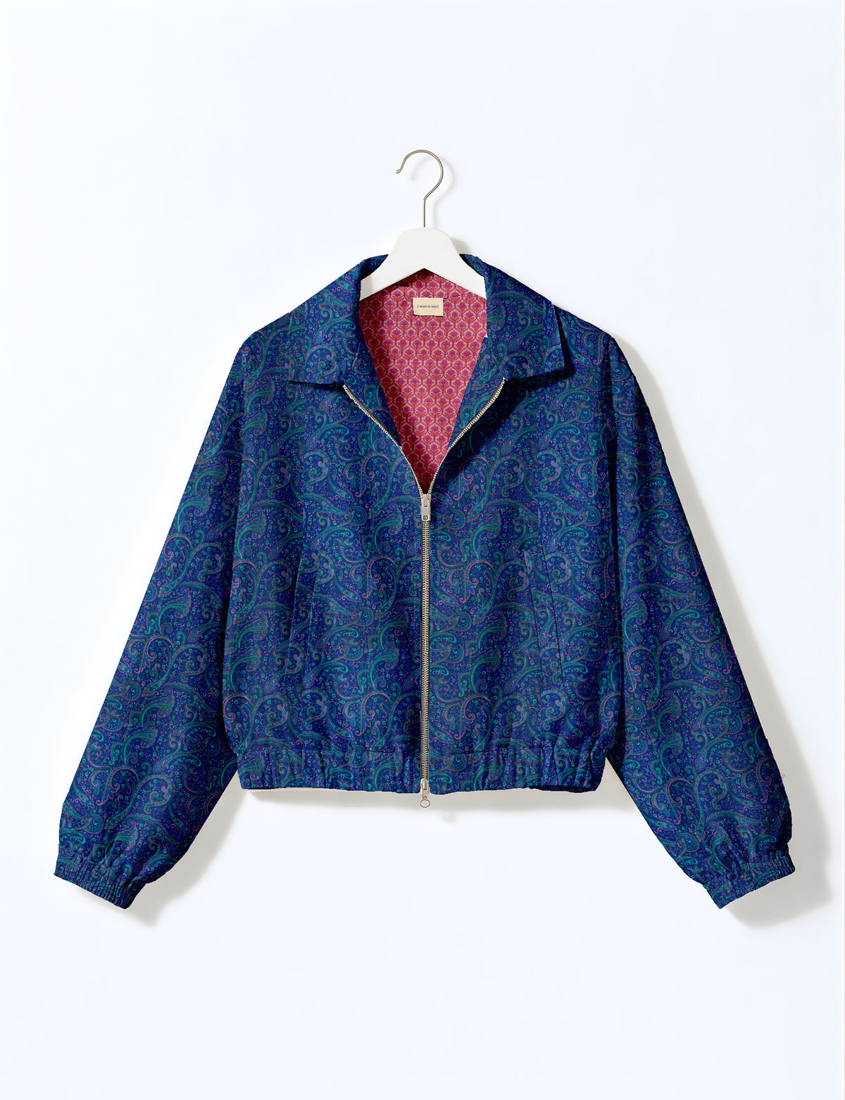 Brown floral bomber jacket with front zipper, elastic cuffs and hem, hanging on white hanger, red floral inner lining visible
