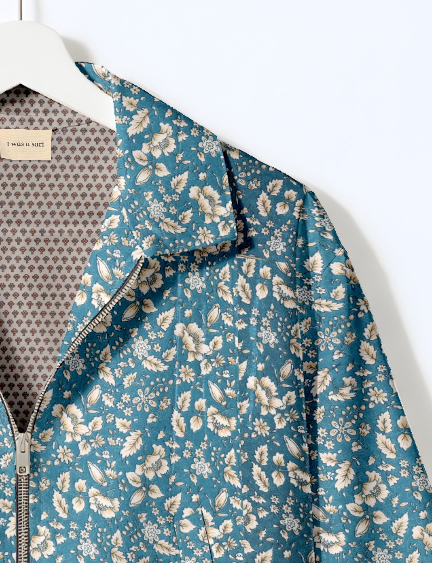 Women's cropped bomber jacket with twin metallic front zippers, welt pockets, elasticated hem and cuffs, and contrast sari print lining.