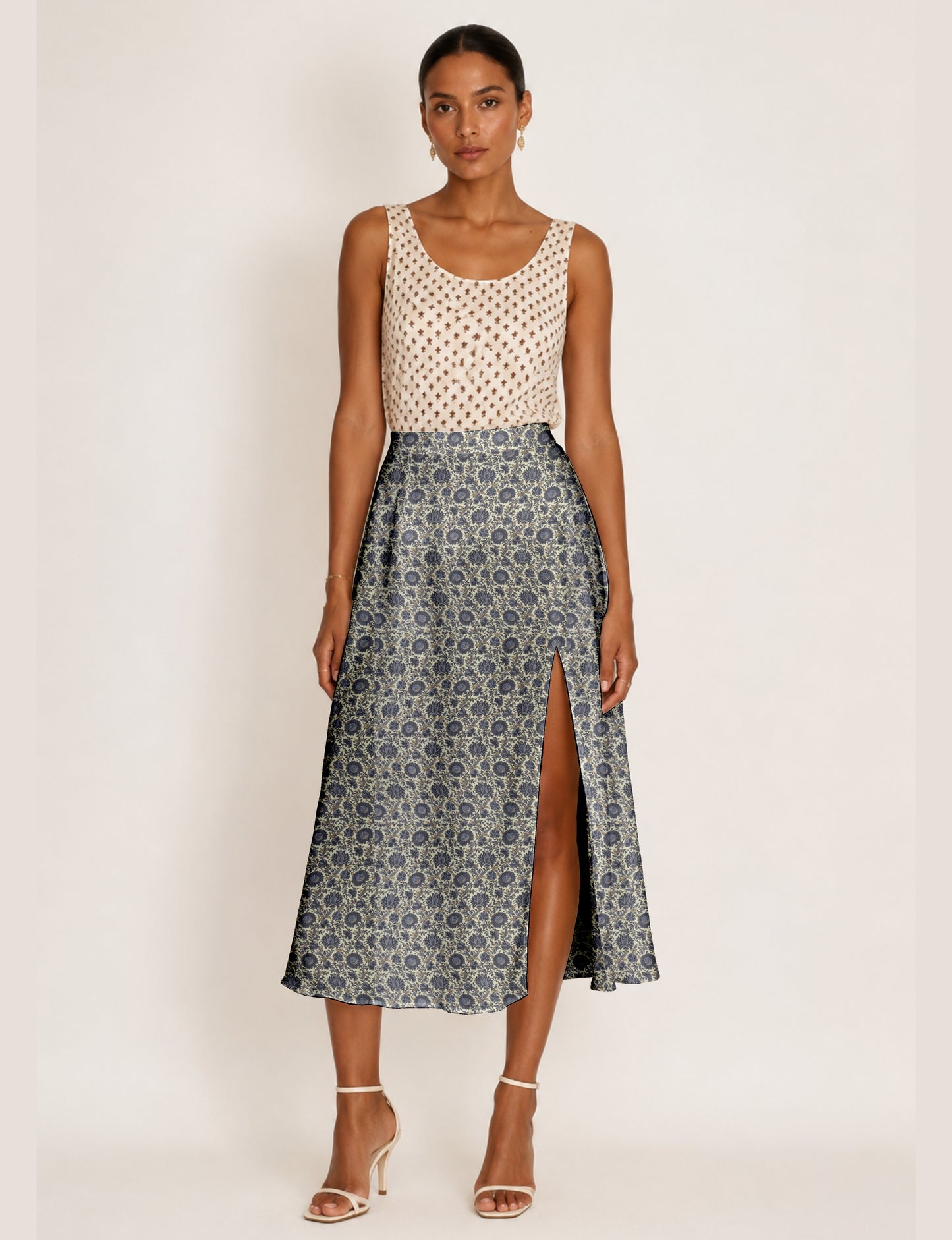 Woman wearing a yellow and navy blue A-line skirt with a slit and a sleeveless beige top with brown micro print