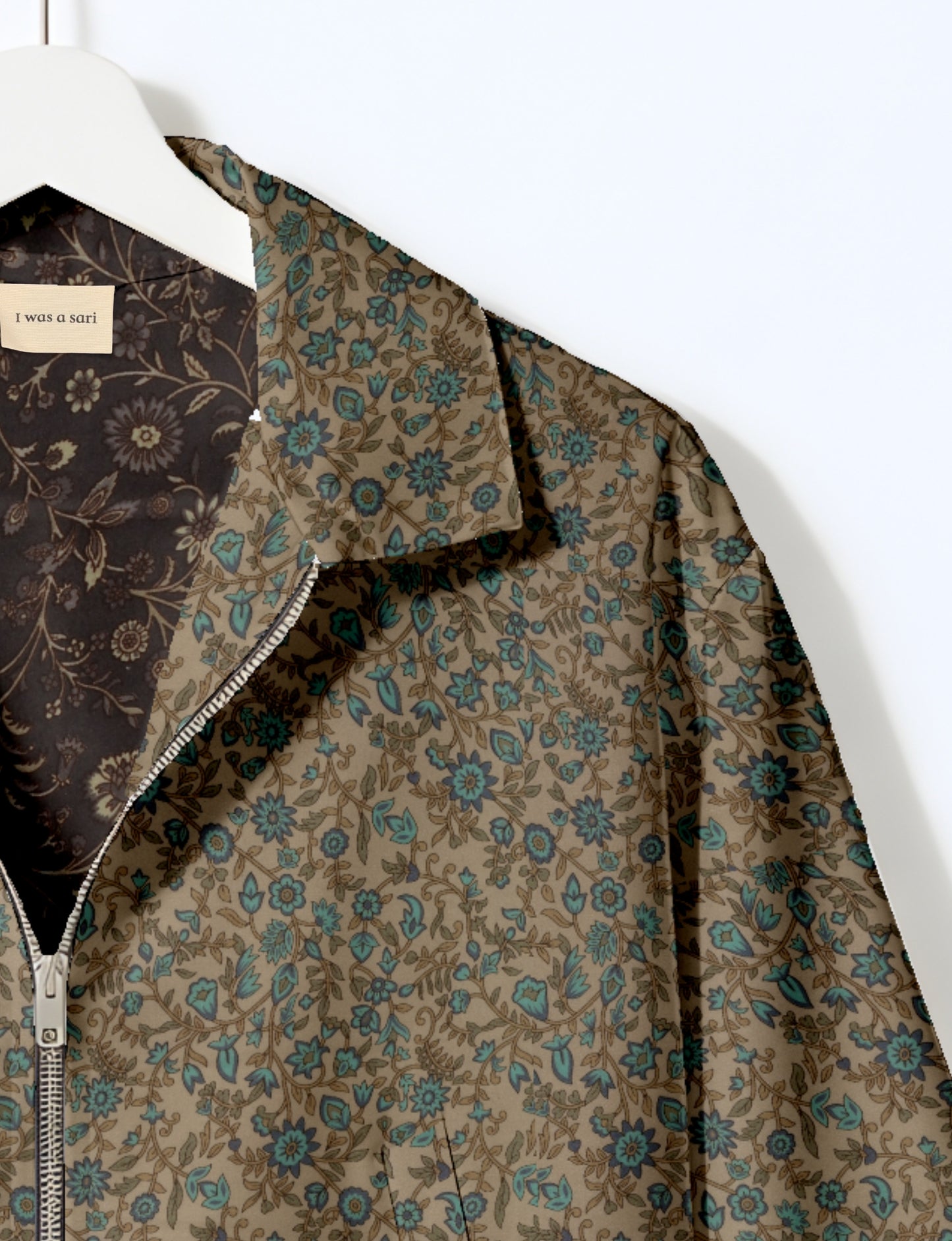 Women's cropped bomber jacket with twin metallic front zippers, welt pockets, elasticated hem and cuffs, and contrast sari print lining.