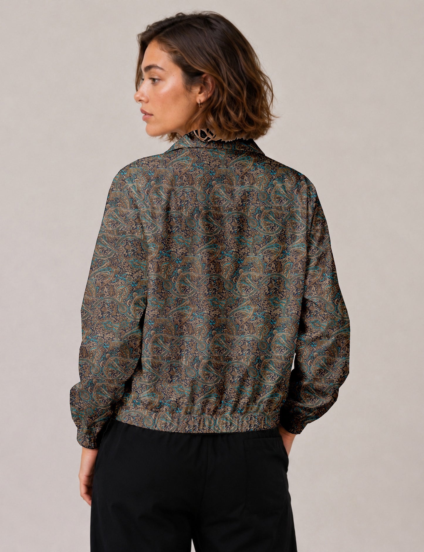 Woman wearing a yellow floral bomber jacket with front zipper, elastic cuffs, and side pockets, shown from front view