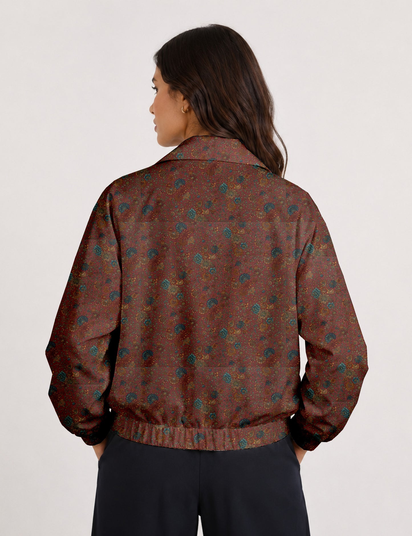 Woman wearing a yellow floral bomber jacket with front zipper, elastic cuffs, and side pockets, shown from front view