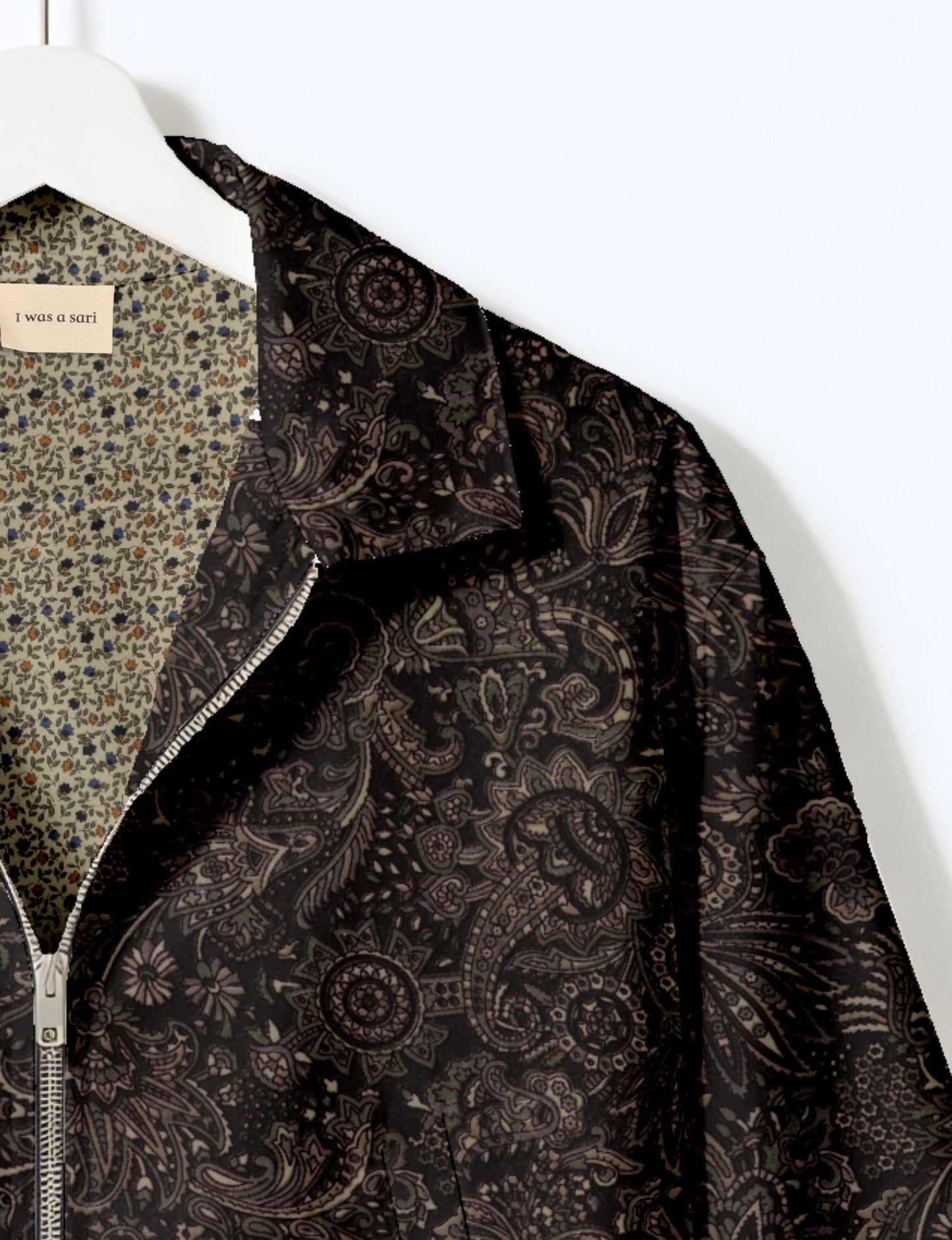 Women's cropped bomber jacket with twin metallic front zippers, welt pockets, elasticated hem and cuffs, and contrast sari print lining.