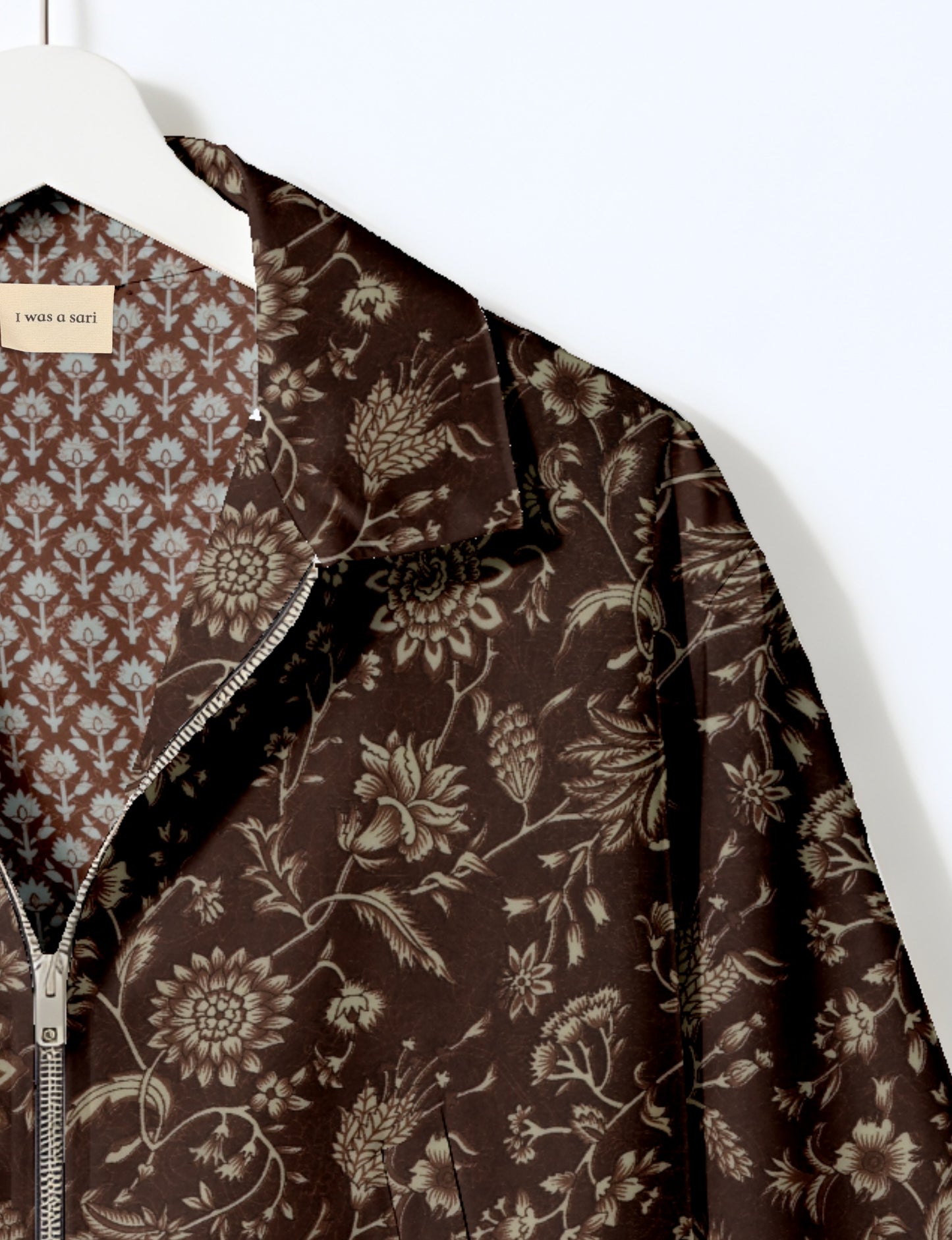 Women's cropped bomber jacket with twin metallic front zippers, welt pockets, elasticated hem and cuffs, and contrast sari print lining.