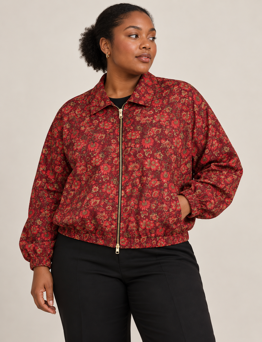 Woman wearing a yellow floral bomber jacket with front zipper, elastic cuffs, and side pockets, shown from front view
