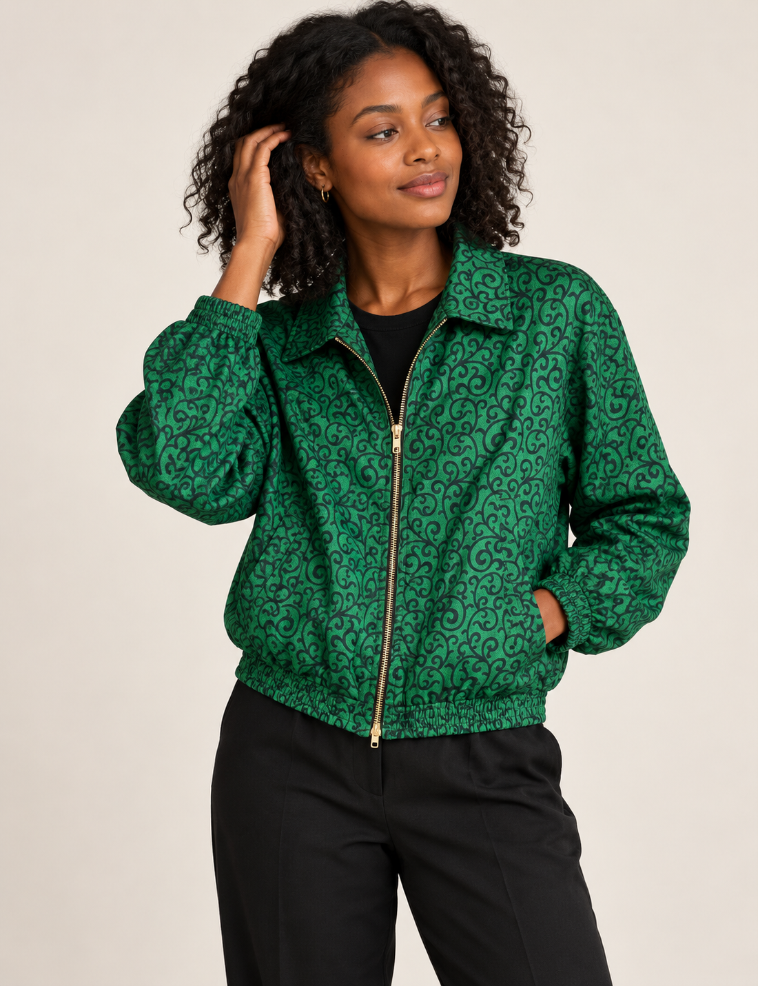 Woman wearing a yellow floral bomber jacket with front zipper, elastic cuffs, and side pockets, shown from front view