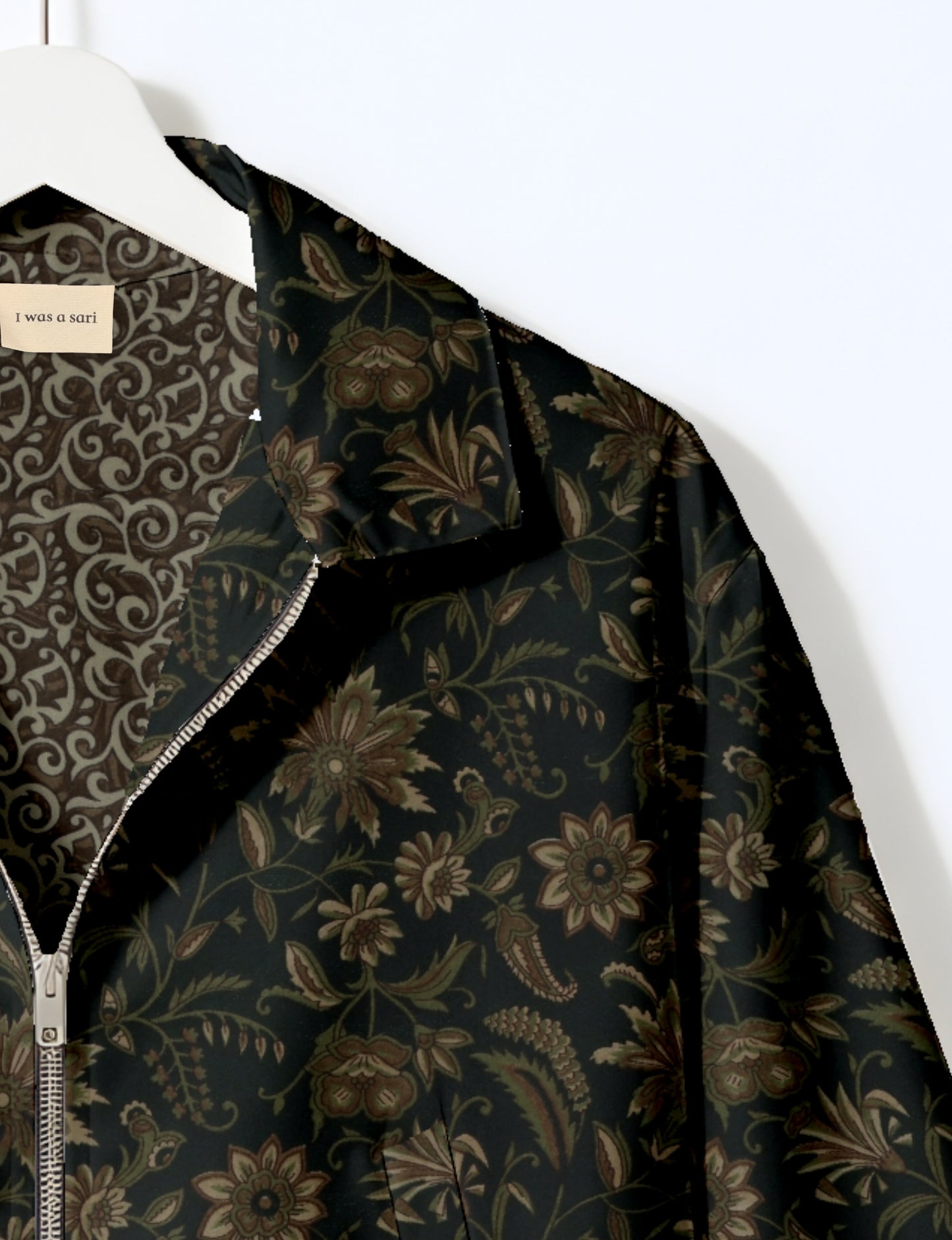 Women's cropped bomber jacket with twin metallic front zippers, welt pockets, elasticated hem and cuffs, and contrast sari print lining.