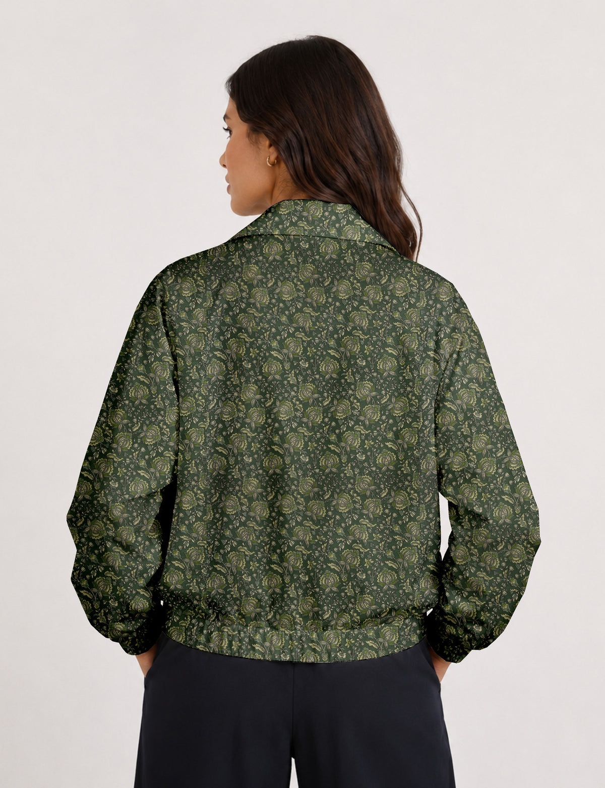 Woman wearing a yellow floral bomber jacket with front zipper, elastic cuffs, and side pockets, shown from front view