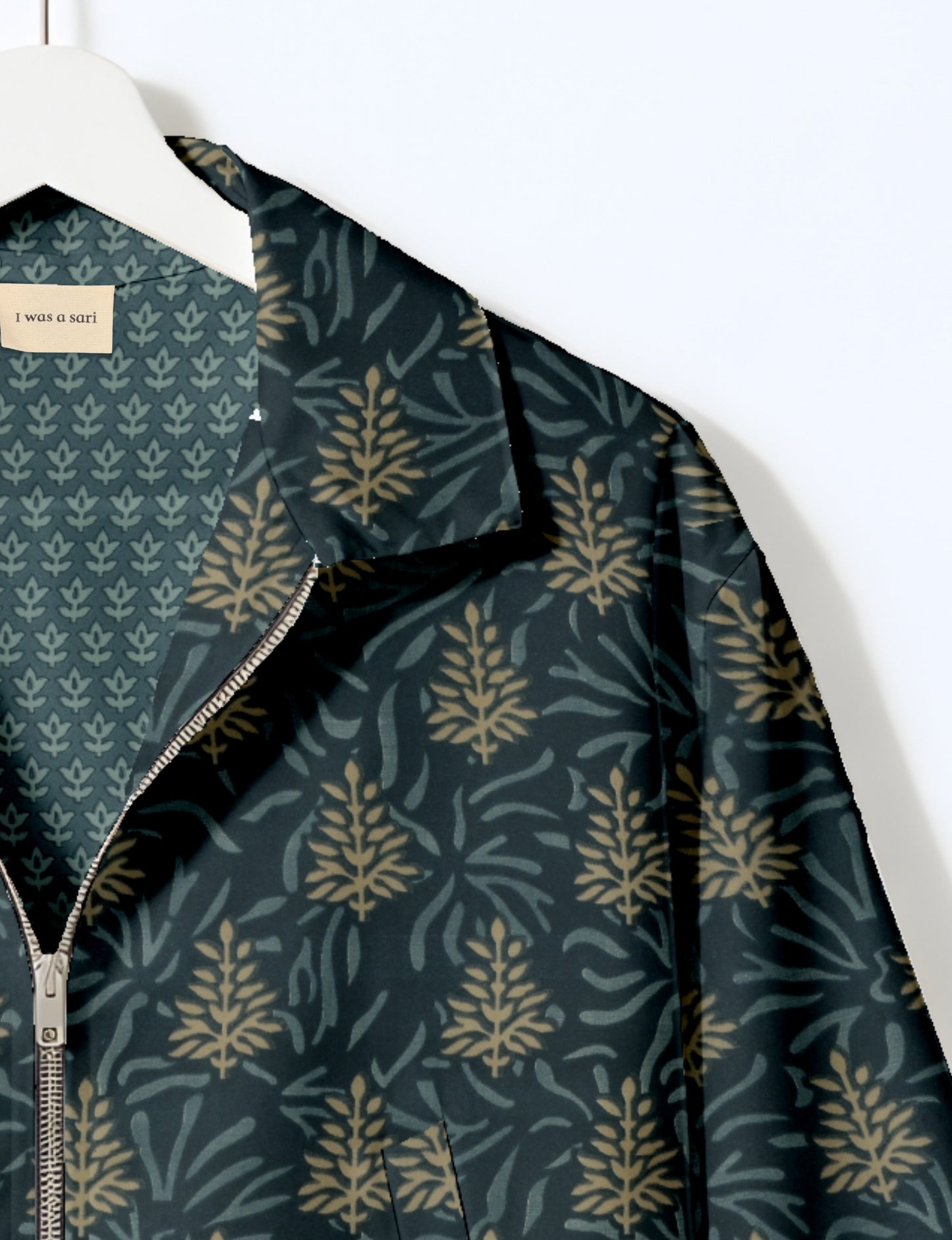 Women's cropped bomber jacket with twin metallic front zippers, welt pockets, elasticated hem and cuffs, and contrast sari print lining.