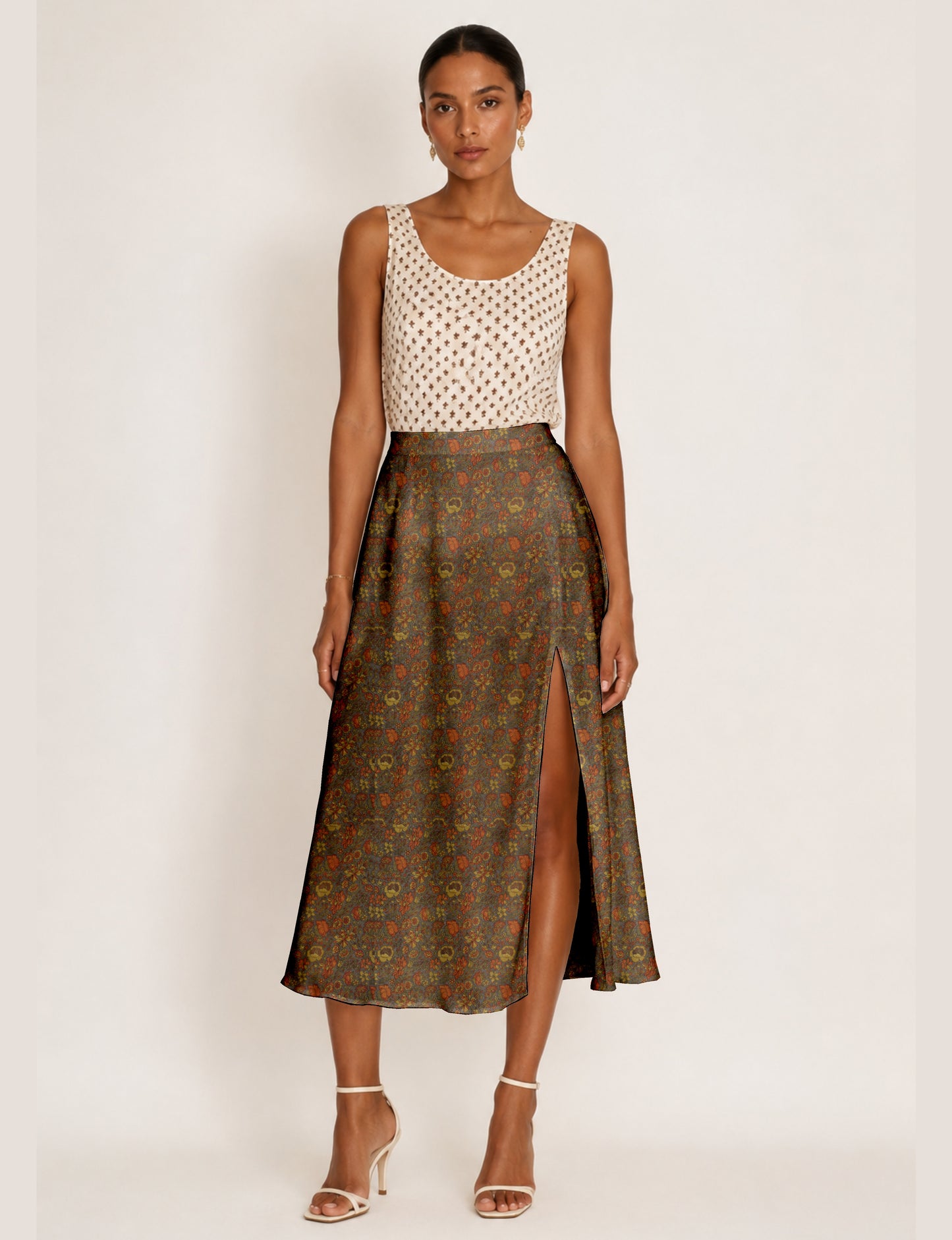 Woman wearing a yellow and black micro patterned A-line skirt with front slit, paired with beige sleeveless top and black