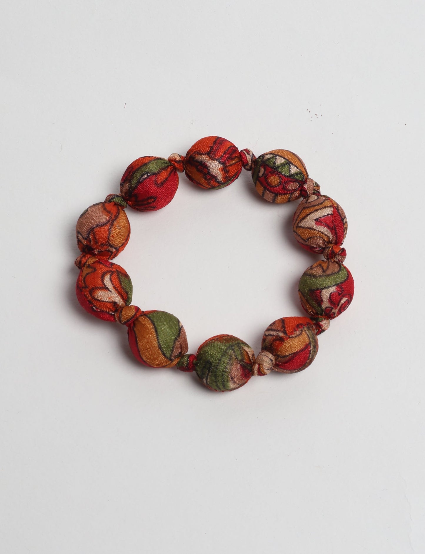 Eco friendly beaded knotted bracelet crafted from upcycled women’s clothing and repurposed sari fabrics, showcasing circular fashion and sustainable apparel.