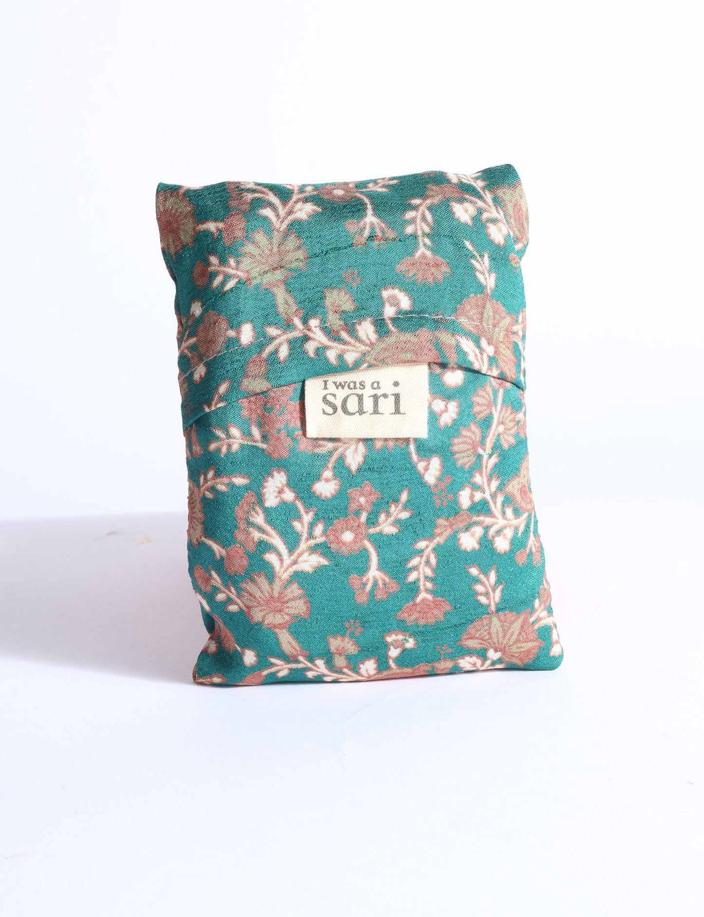 Blue reusable bag with multicolor tropical floral pattern folded with "I was a sari" label visible on front