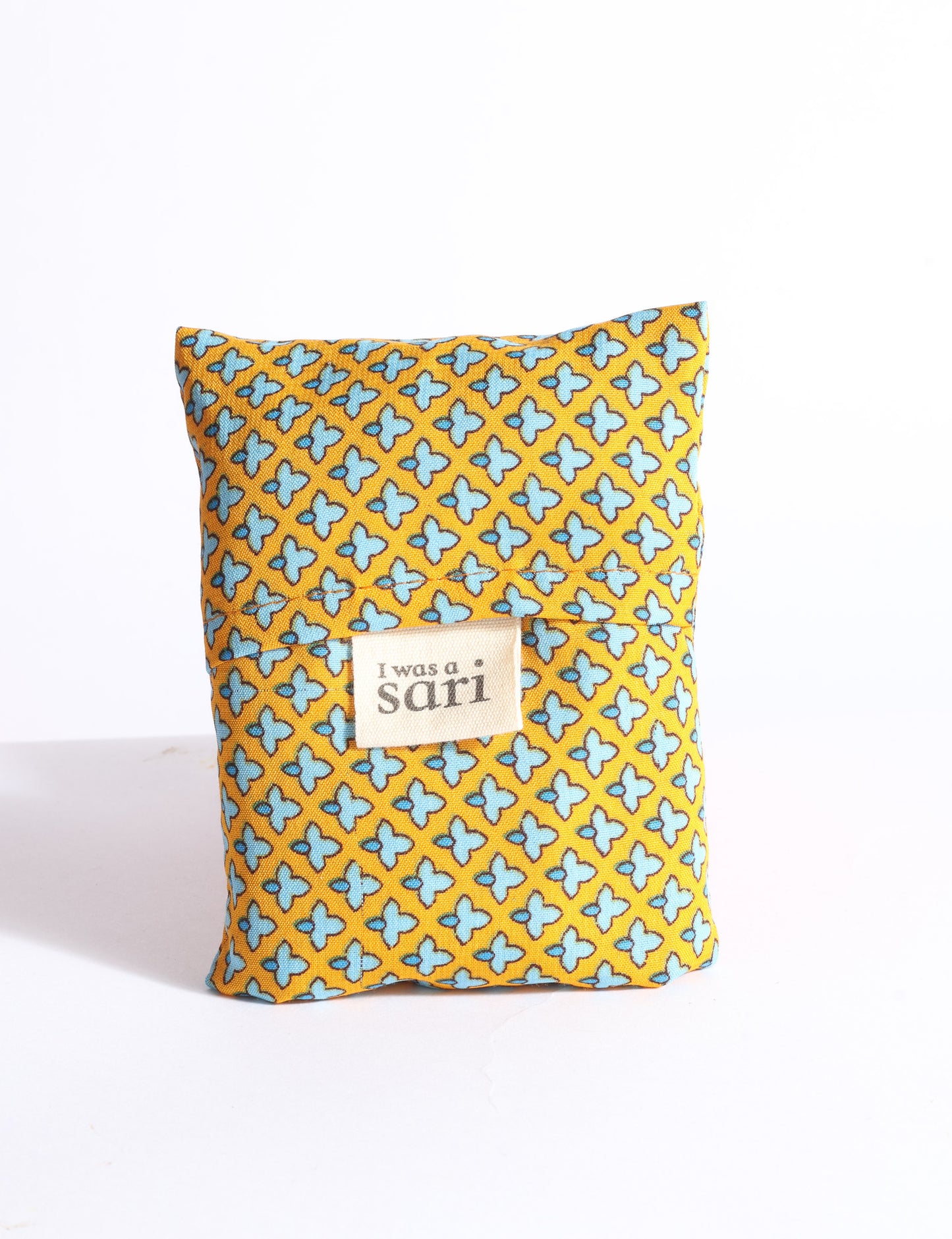 Blue reusable bag with multicolor tropical floral pattern folded with "I was a sari" label visible on front