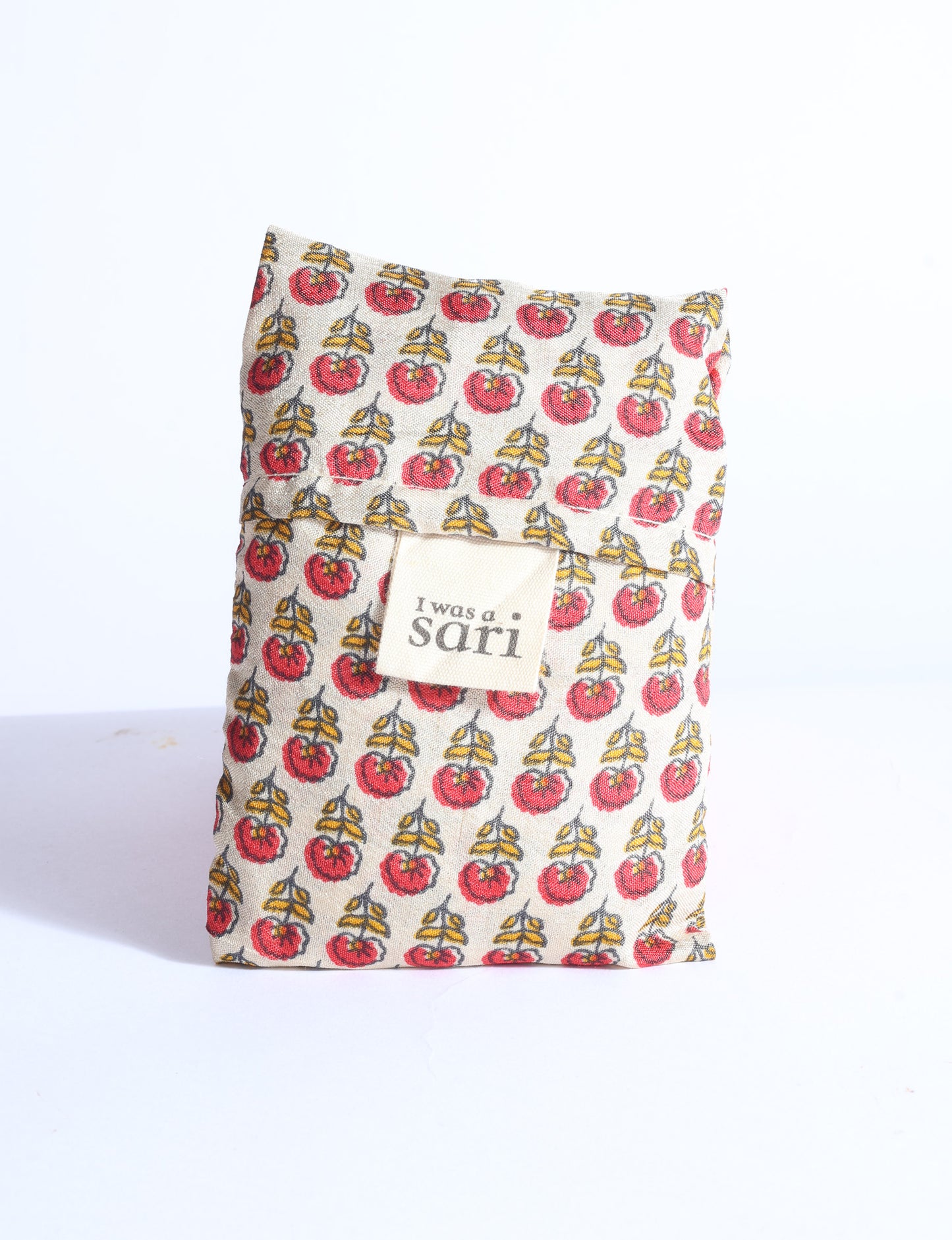 Blue reusable bag with multicolor tropical floral pattern folded with "I was a sari" label visible on front