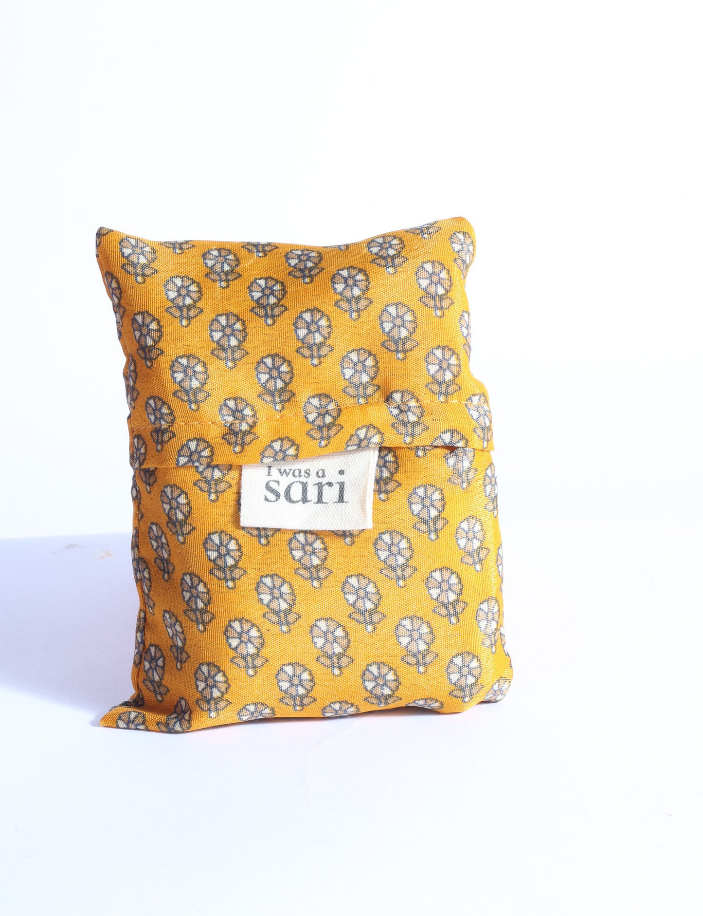 Blue reusable bag with multicolor tropical floral pattern folded with "I was a sari" label visible on front