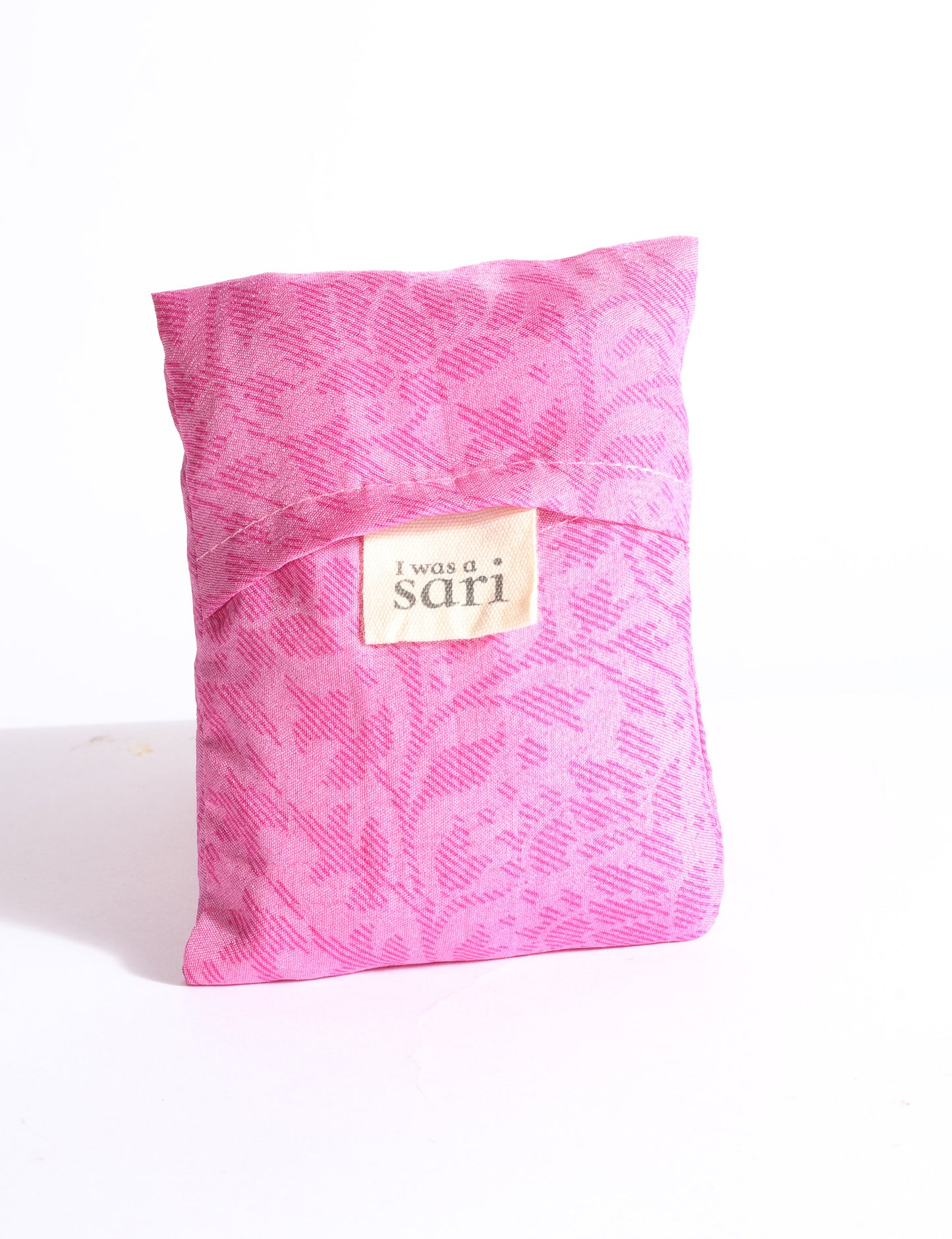Blue reusable bag with multicolor tropical floral pattern folded with "I was a sari" label visible on front