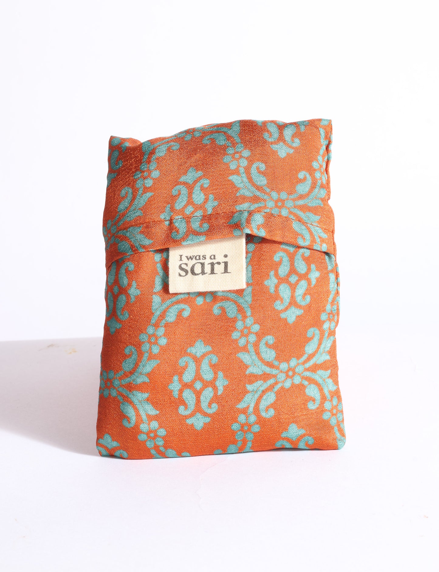 Blue reusable bag with multicolor tropical floral pattern folded with "I was a sari" label visible on front