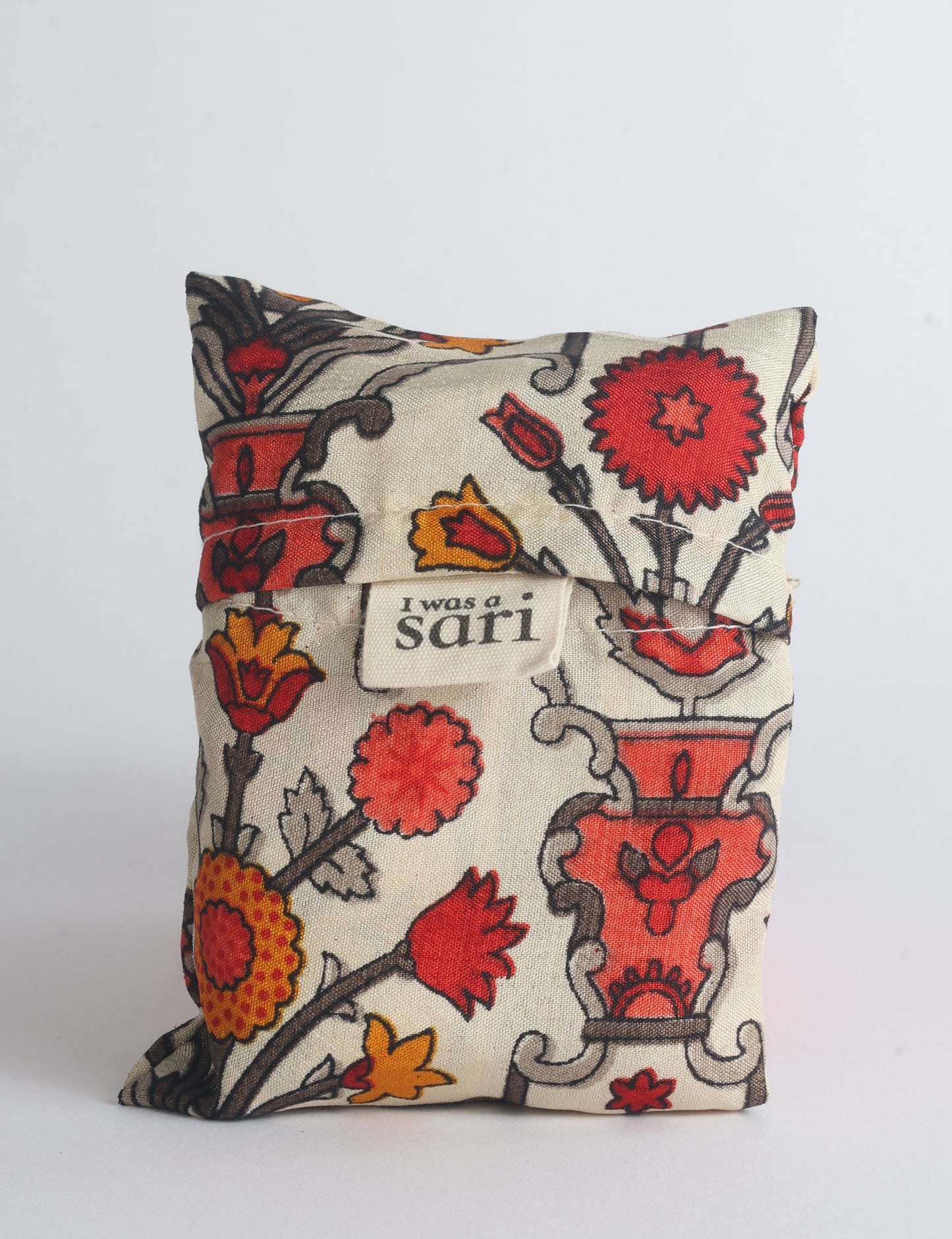 Blue reusable bag with multicolor tropical floral pattern folded with "I was a sari" label visible on front