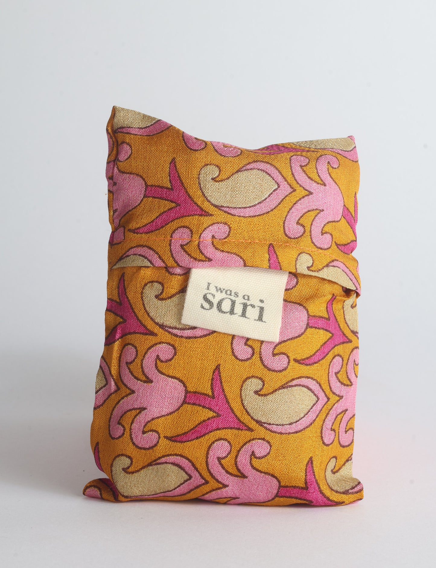 Blue reusable bag with multicolor tropical floral pattern folded with "I was a sari" label visible on front