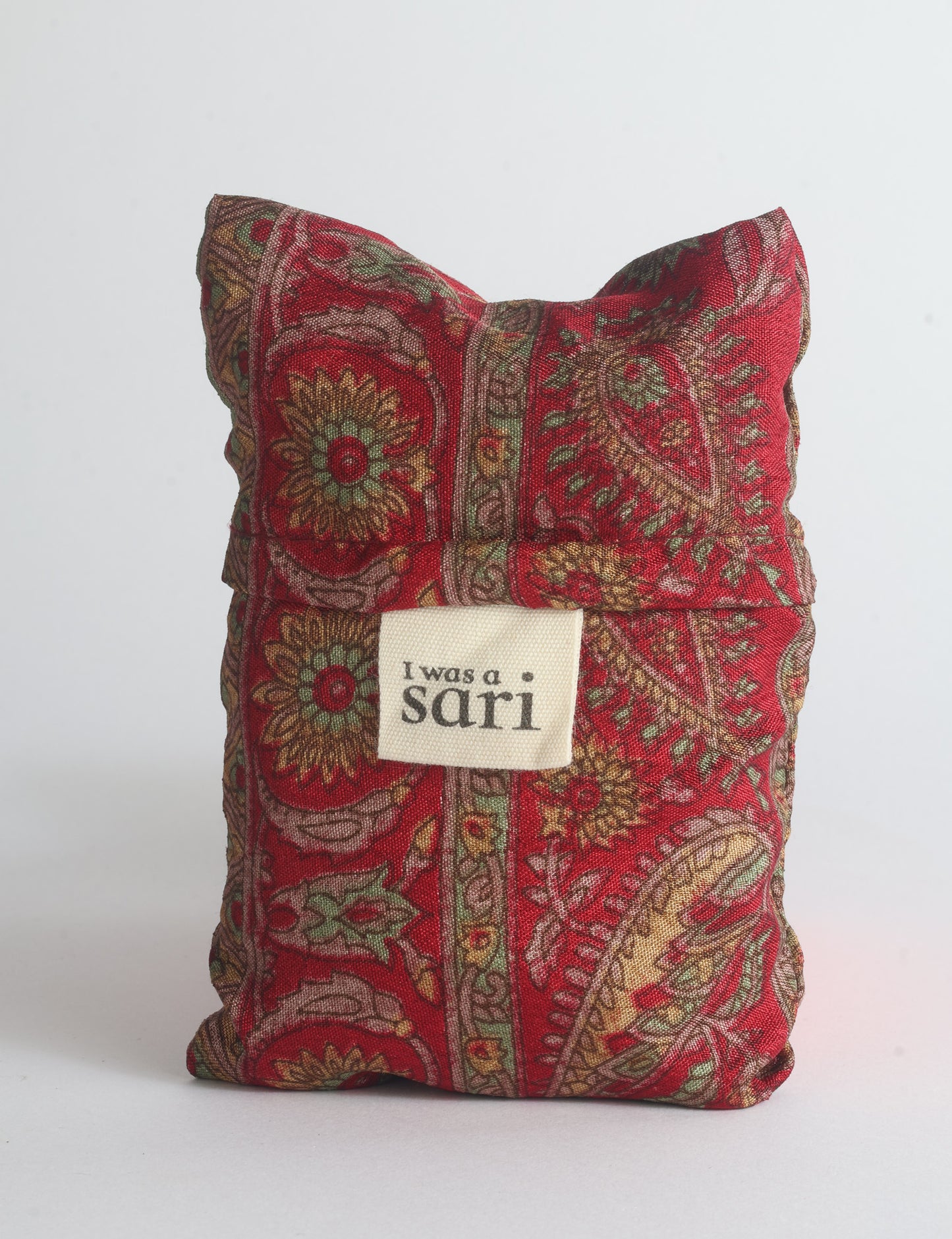Blue reusable bag with multicolor tropical floral pattern folded with "I was a sari" label visible on front