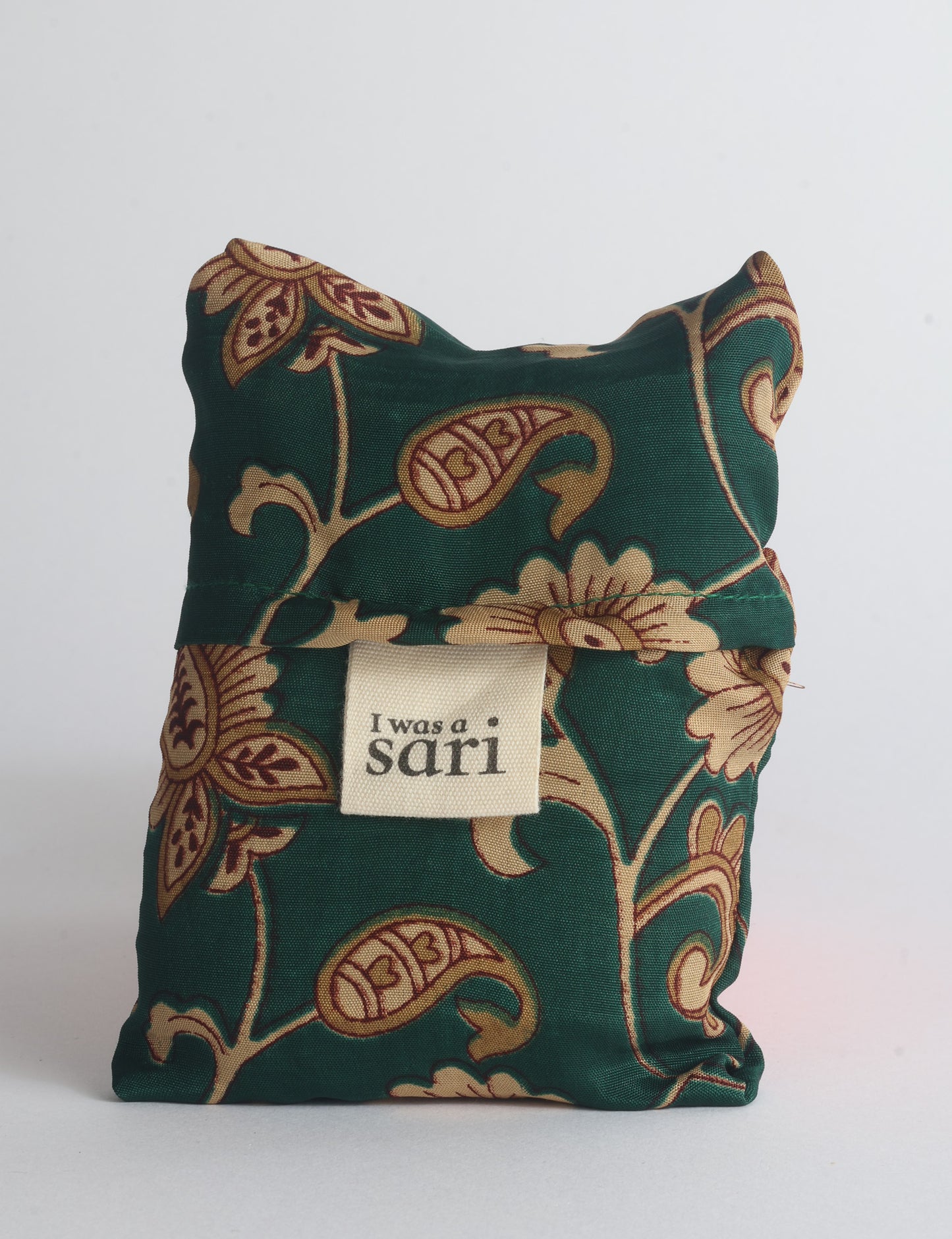 Blue reusable bag with multicolor tropical floral pattern folded with "I was a sari" label visible on front