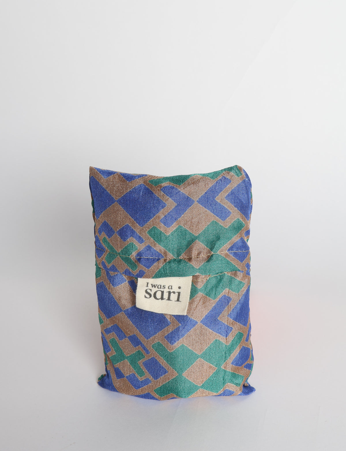 Blue reusable bag with multicolor tropical floral pattern folded with "I was a sari" label visible on front
