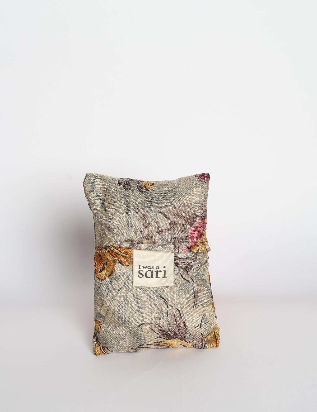Blue reusable bag with multicolor tropical floral pattern folded with "I was a sari" label visible on front