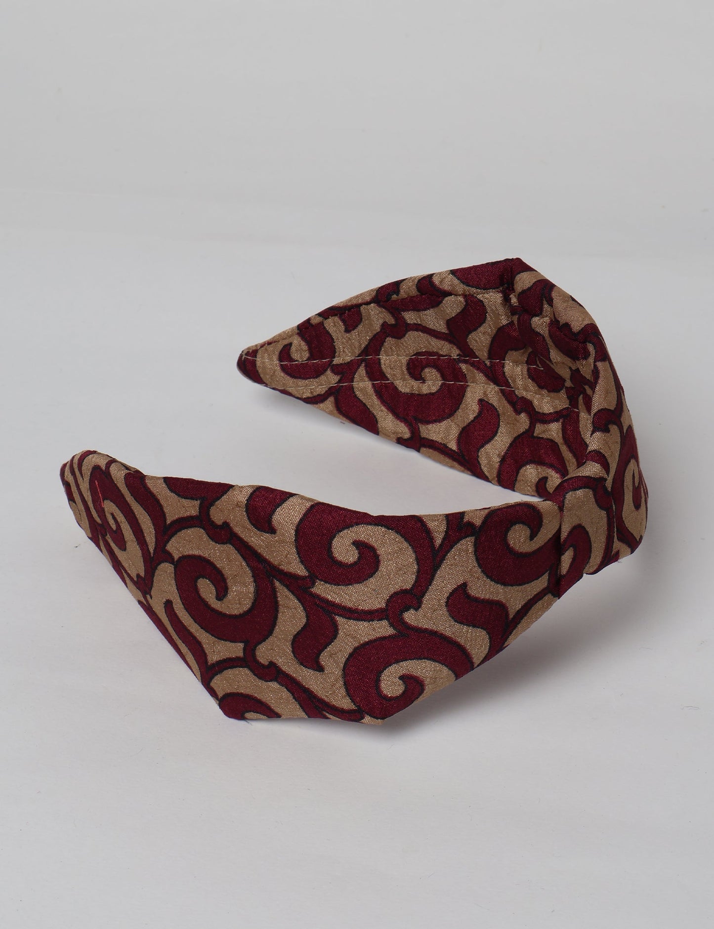 Upcycled sari hairband with central knot, handmade in India — an eco friendly fashion accessory representing green fashion, upcycled women’s clothing, fair trade fashion, and earth friendly clothing made from recycled sari textiles.