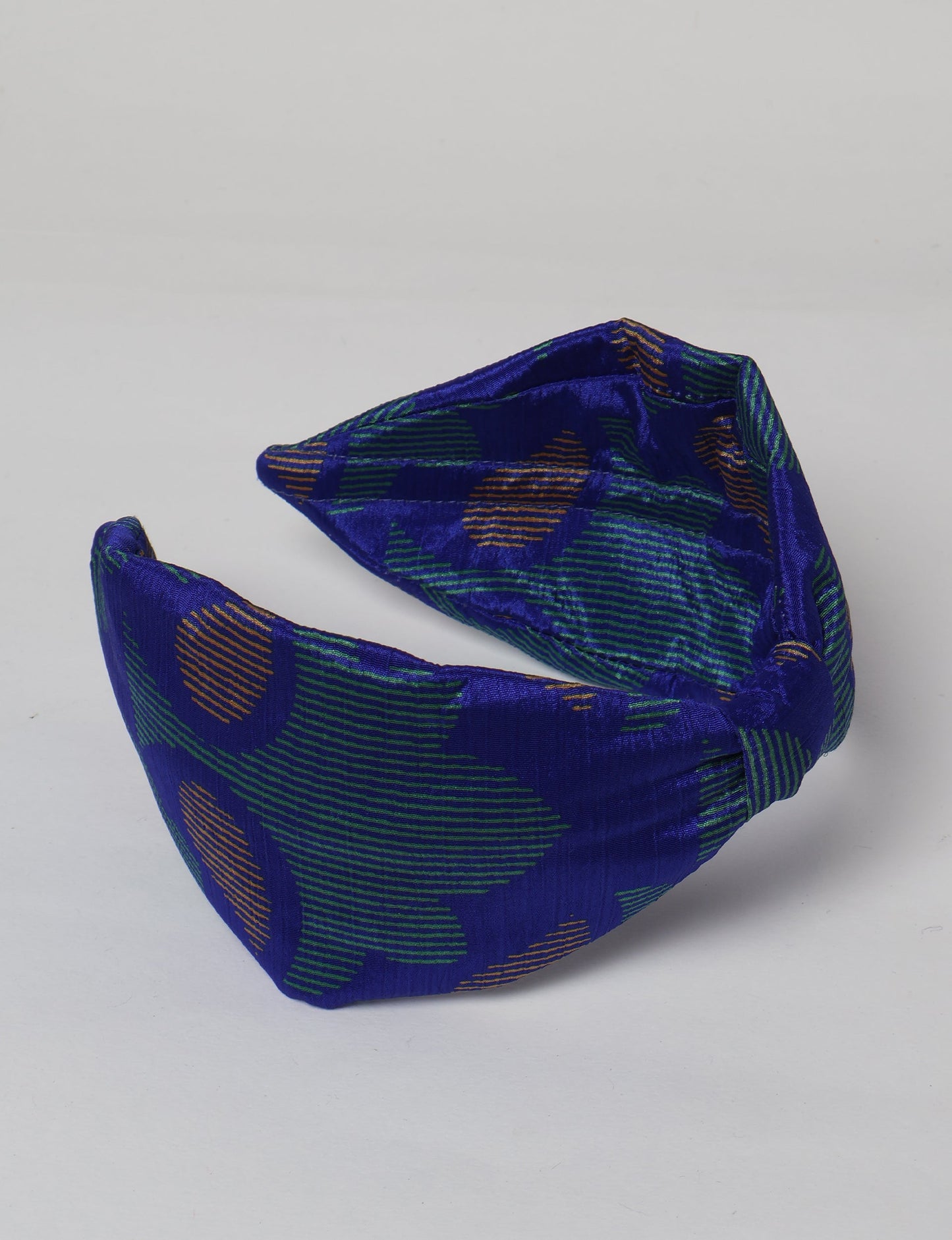 Upcycled sari hairband with central knot, handmade in India — an eco friendly fashion accessory representing green fashion, upcycled women’s clothing, fair trade fashion, and earth friendly clothing made from recycled sari textiles.