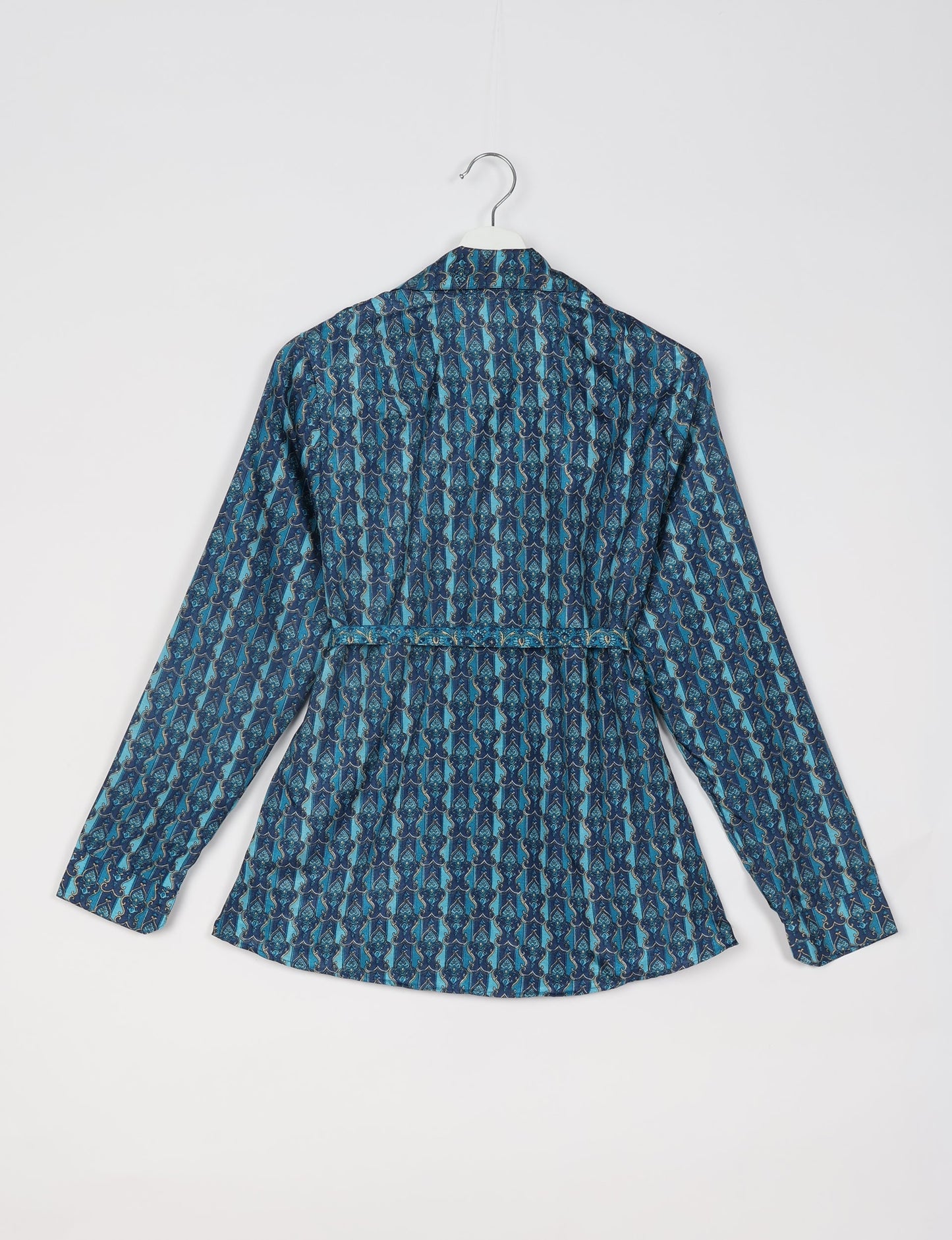 Experience sustainable fashion with our classic slim-fit shirt, crafted with ethical and green values. The shirt, designed for minimal waste, features a tie-up waist belt or neck tie, semi-spread collar, and regular shirt cuffs. Versatile and eco-friendly, wear it tucked in, unbuttoned over a tank top, or knotted at the waist for a unique style.