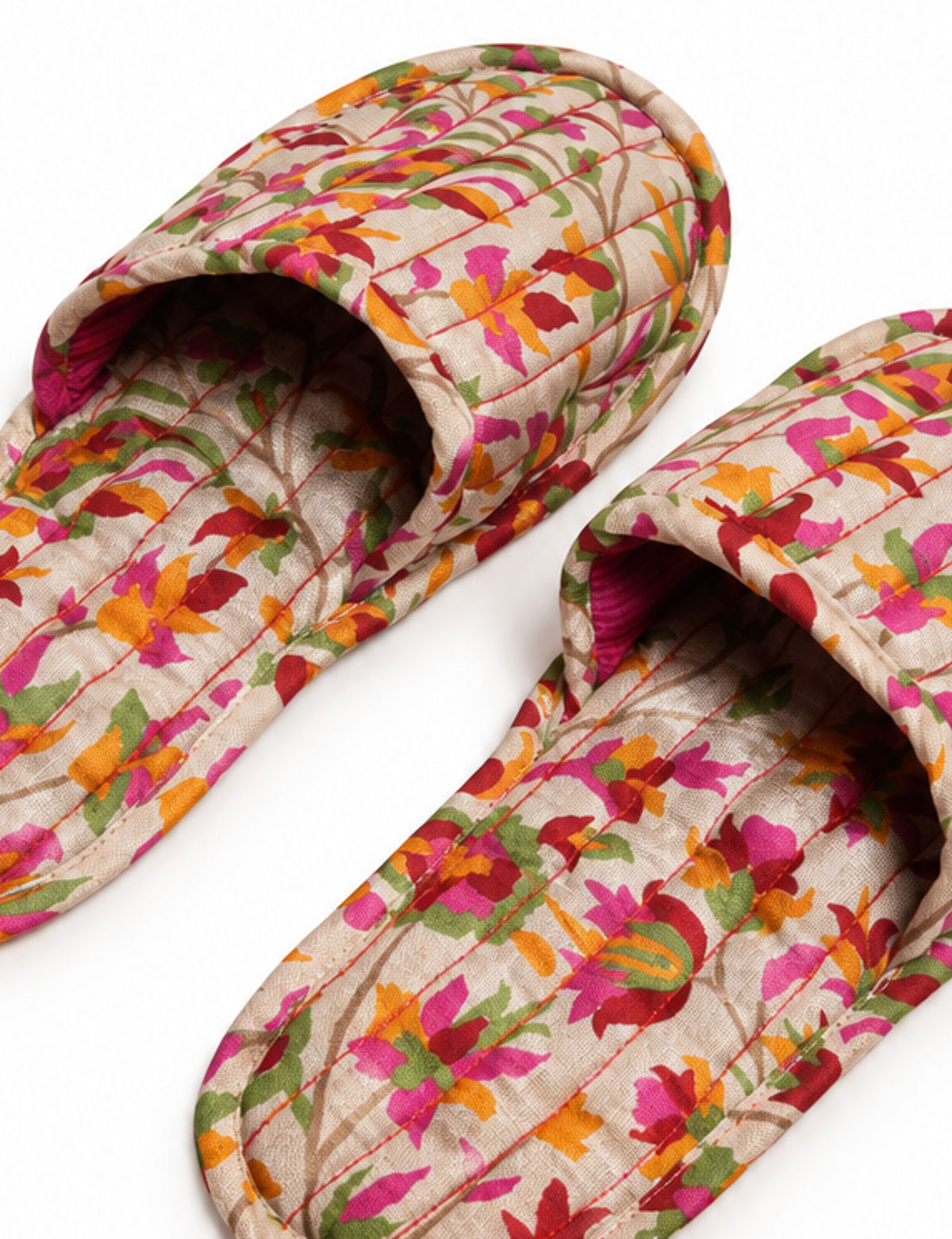 Blue quilted slippers with paisley pattern in shades of purple, green, and pink, shown from top view on white background