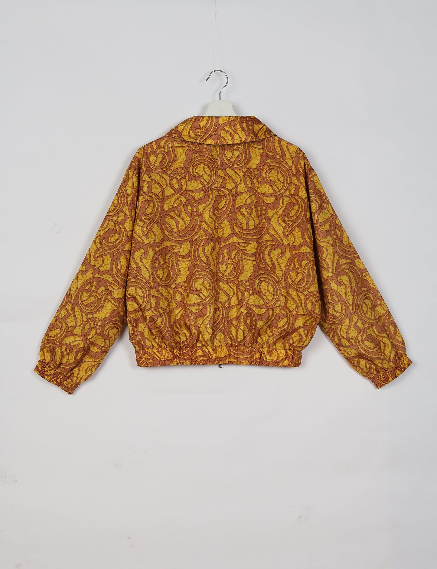 Upcycled Bomber Jacket made from recycled sari materials, featuring a cute cropped shape, elasticated hem and cuffs, and contrast sari print lining. Sustainable apparel promoting eco-friendly fashion and ethical clothing.