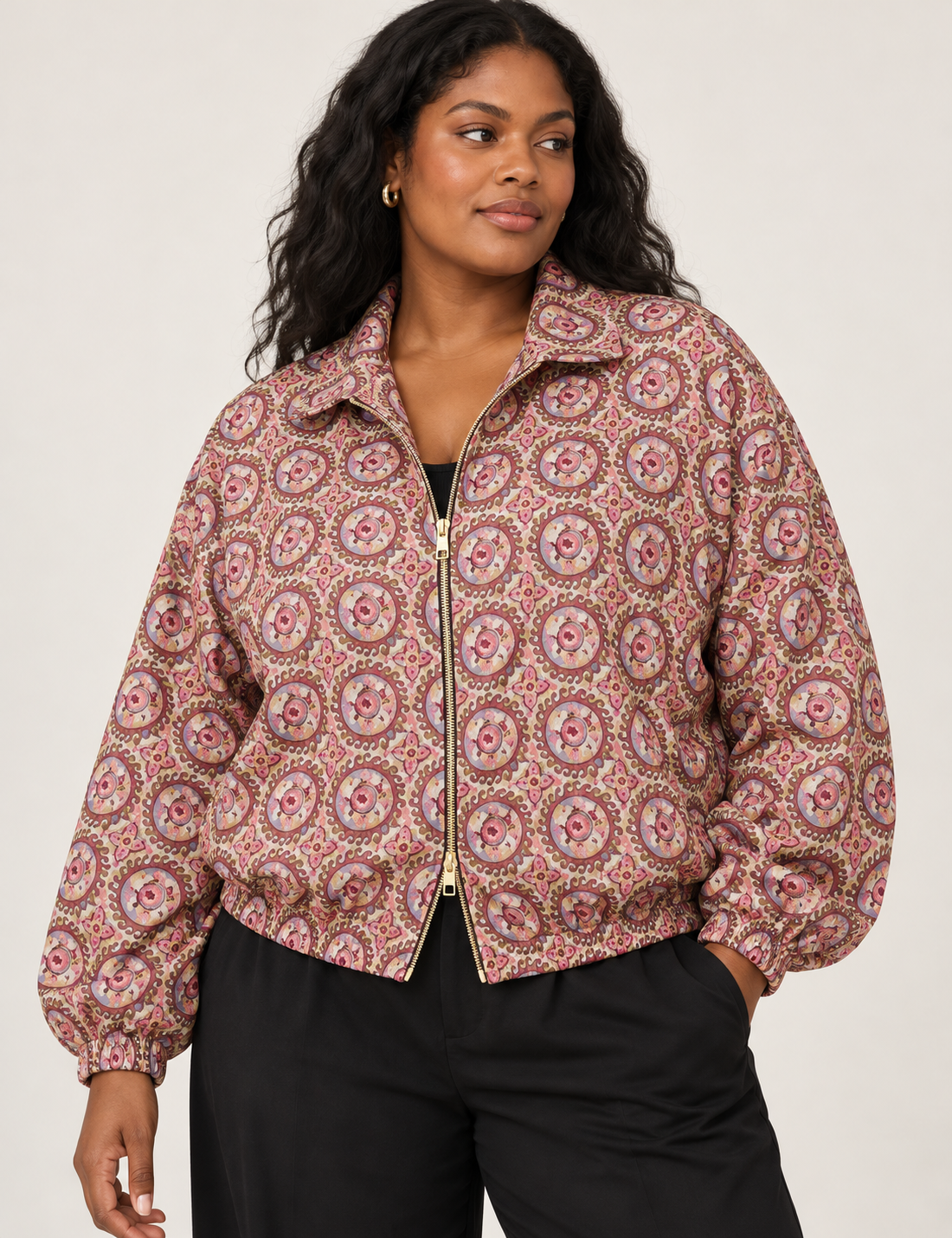 Woman wearing a yellow floral bomber jacket with front zipper, elastic cuffs, and side pockets, shown from front view