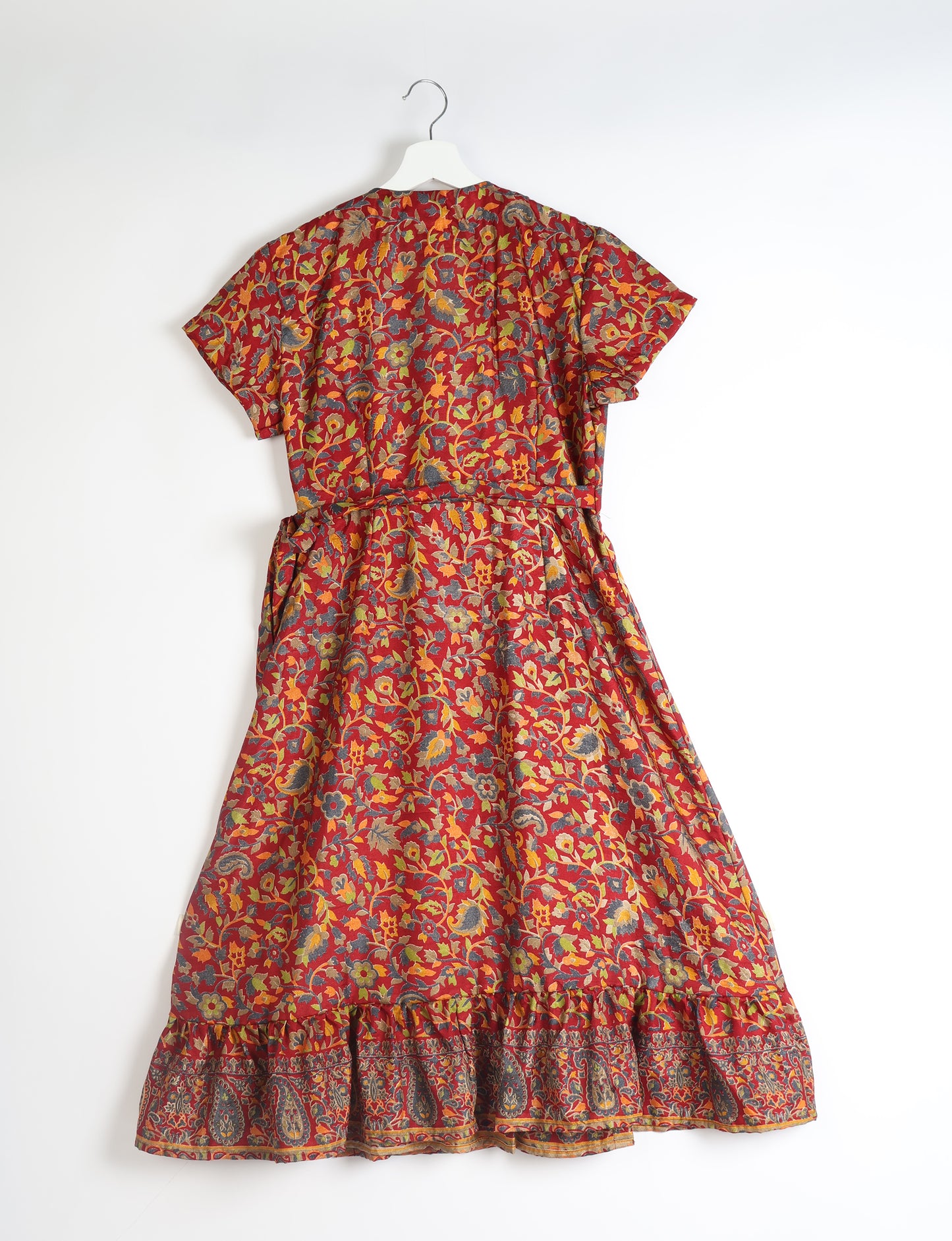 Embrace timeless elegance with our MIDI WRAP DRESS – a midi-length beauty featuring a v-neck, flattery from all angles, and a charming sari belt. Crafted from sustainable materials, this dress embodies ethical clothing and green fashion. Sophisticated with a frill tier at the hem and short cap sleeves, this dress is perfect for any occasion. Tie up the beautifully crafted sari belt on the side for a versatile, stylish, and eco-friendly look.
